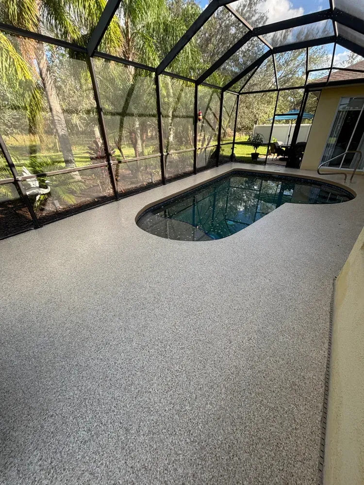 There is a swimming pool inside of a screened in area.