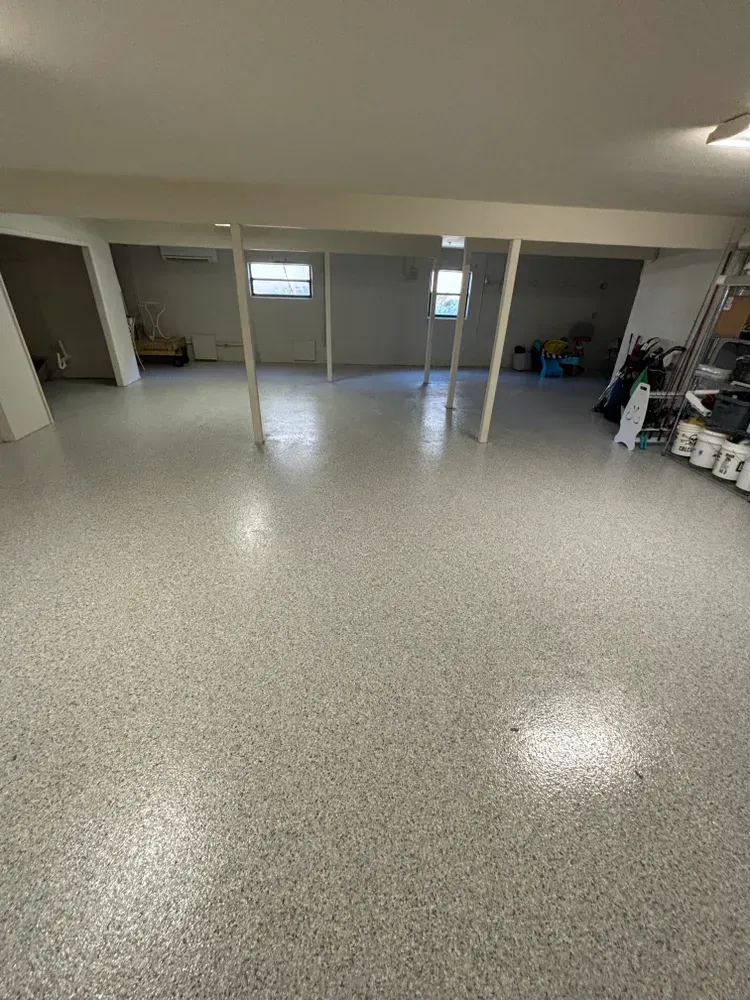 A large empty basement with a white floor.