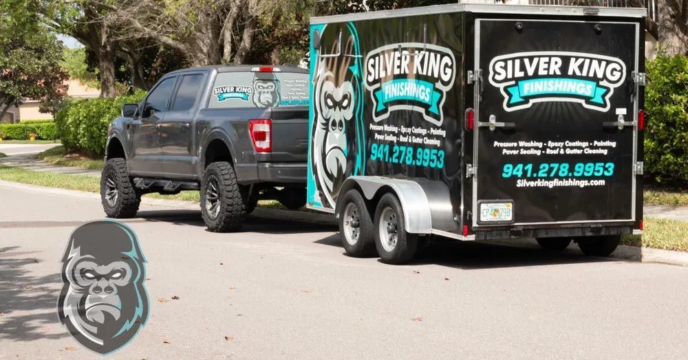 Two silver king trailers are parked next to each other on the side of the road.