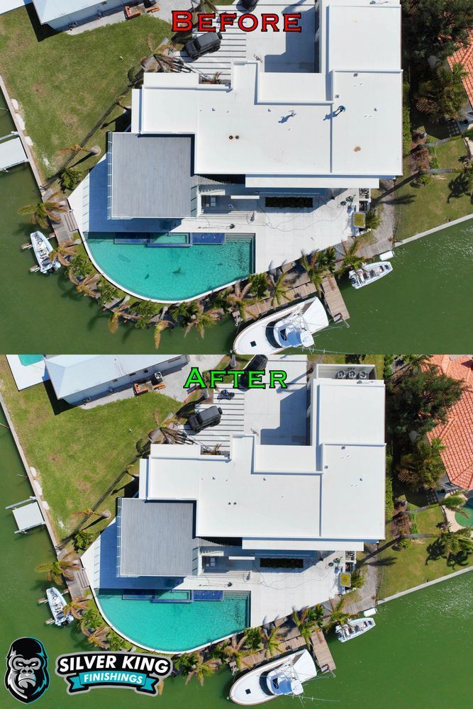 An aerial view of a large house with a pool and boats in front of it.