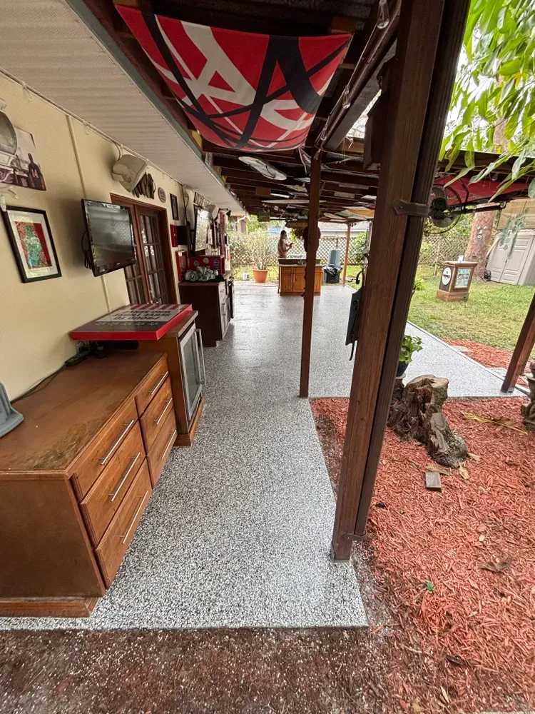 A long hallway leading to a patio with a sign on the ceiling.