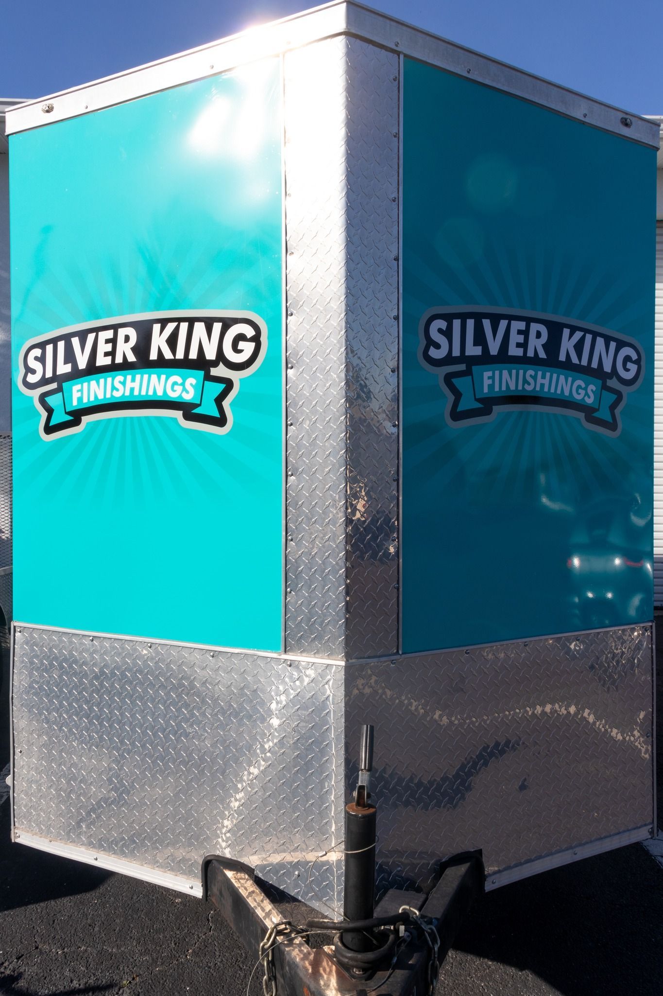 A silver king trailer is parked in a parking lot