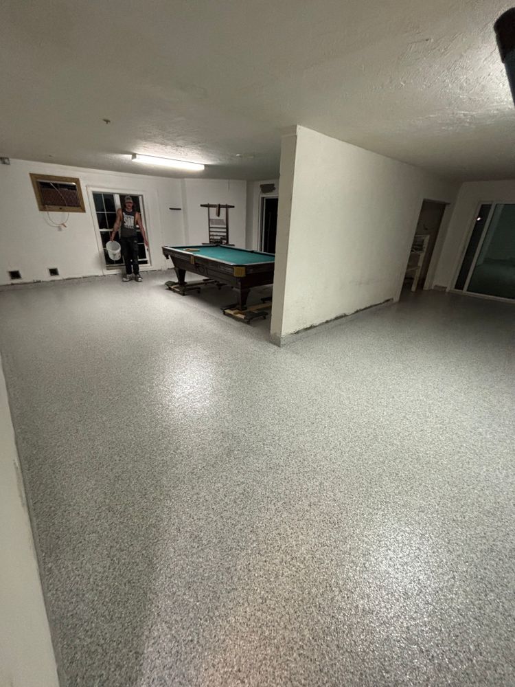 A man is standing in a room with a pool table.
