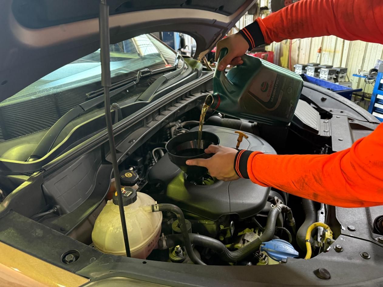 A Person is Pouring Oil Into a Car Engine — ABIV Automotive In Richlands, QLD