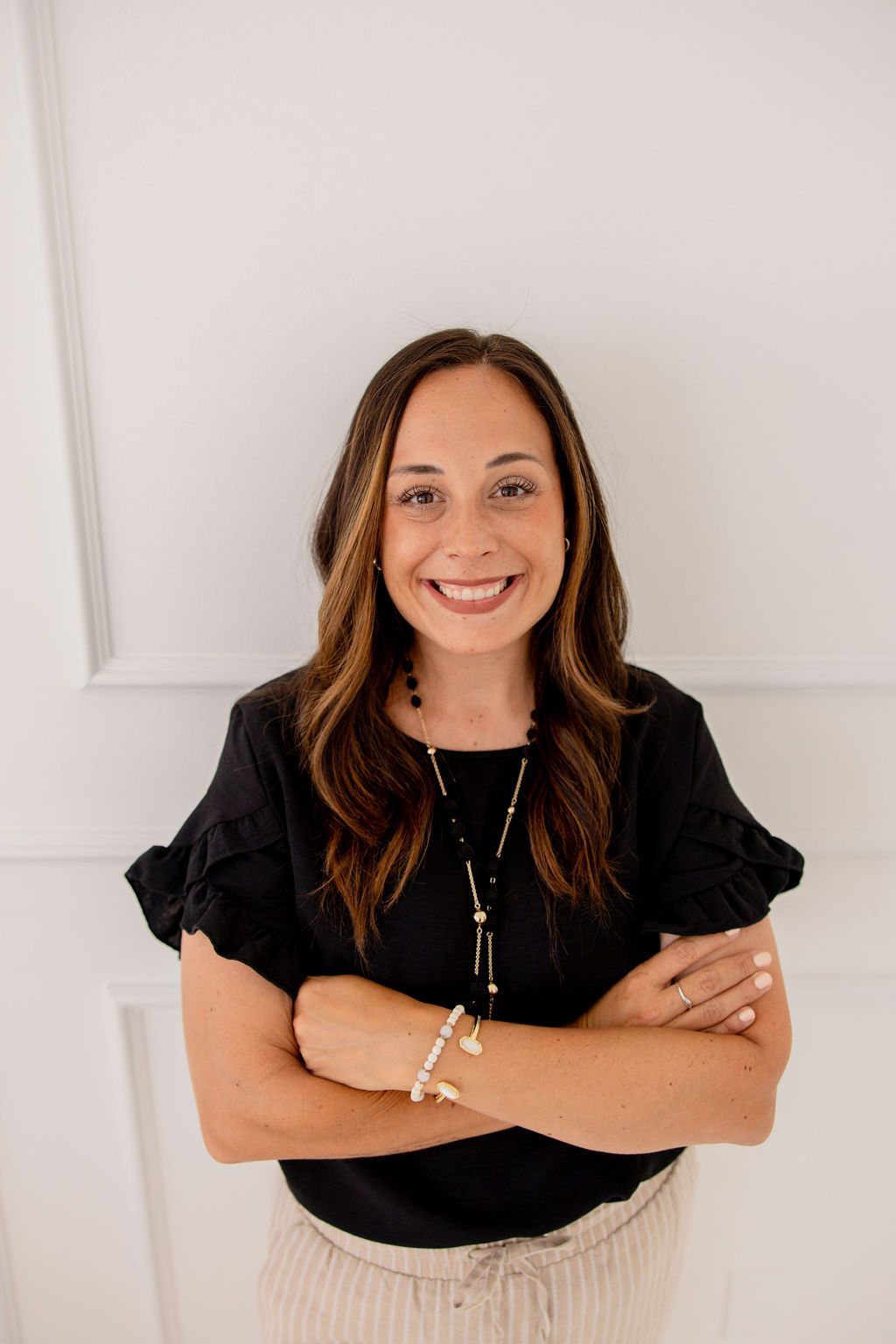 A dining room with a table and chairs and a wooden staircase.