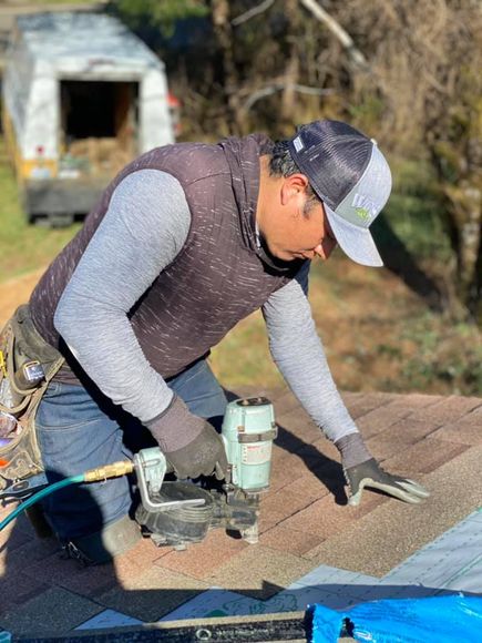An employee performing roofing services in Olympia, WA