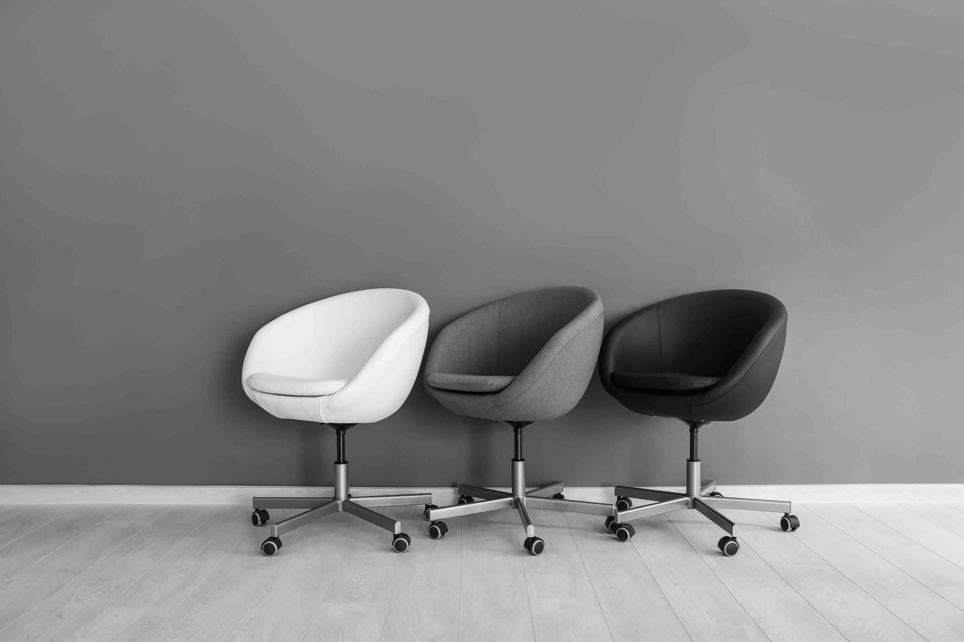 A depiction of a grey color scheme in a room with grey flooring and also office chairs  with grey tones