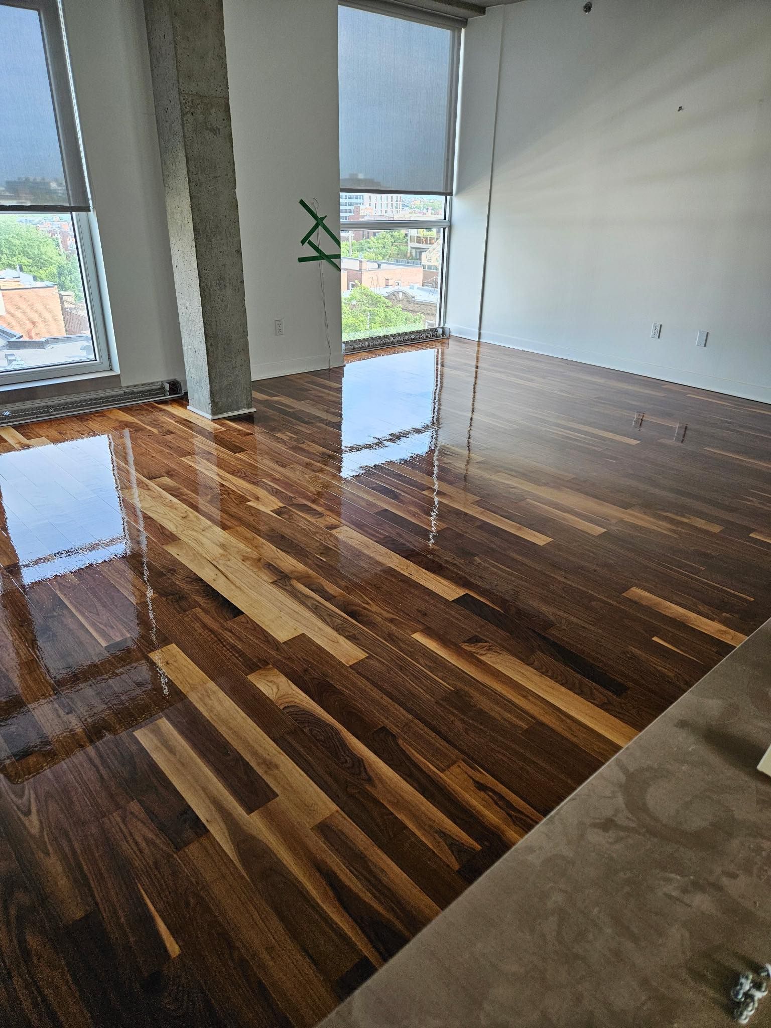 Une pièce avec un plancher en bois et une grande fenêtre.