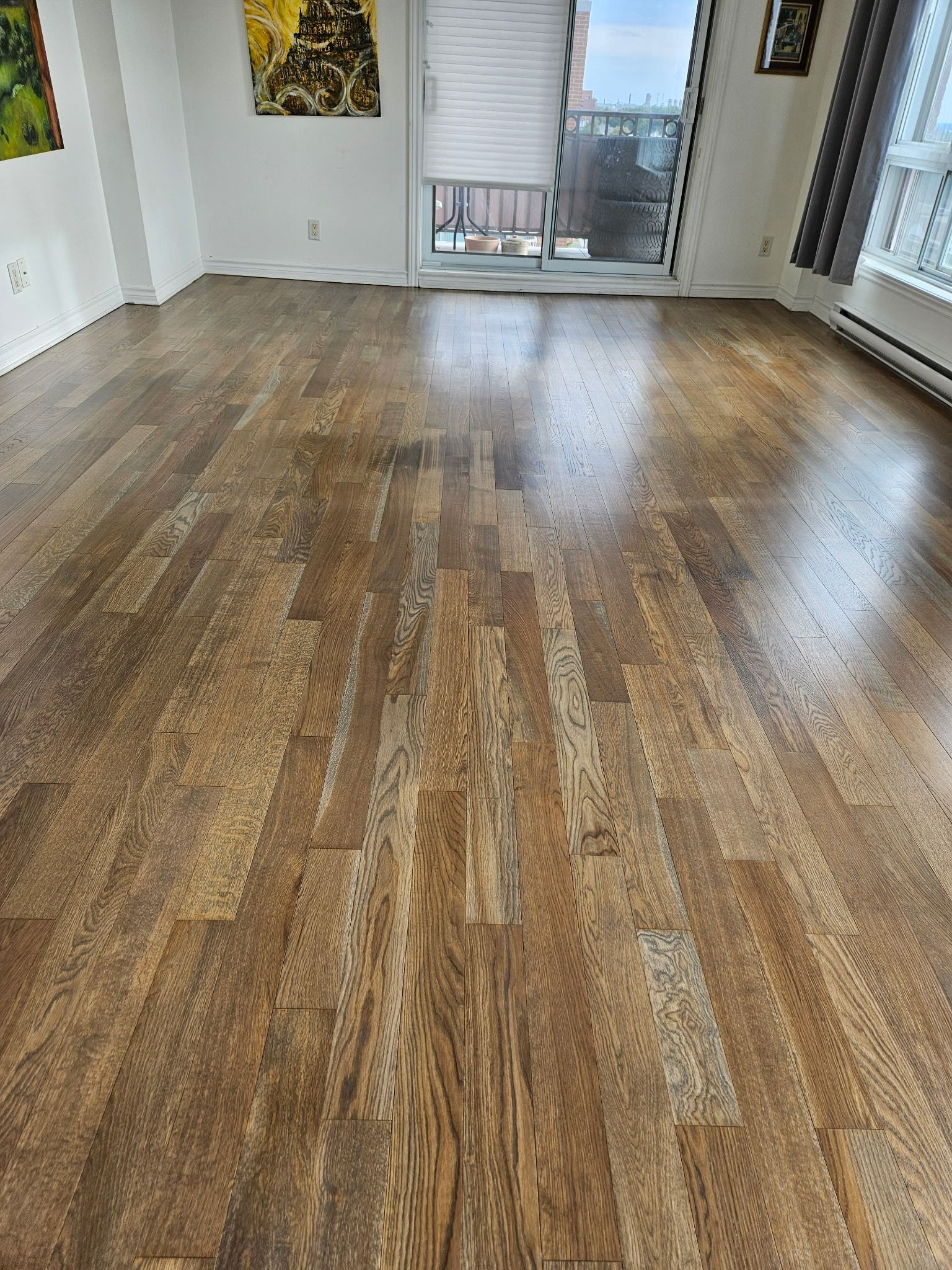 Un salon avec parquet et porte coulissante en verre.