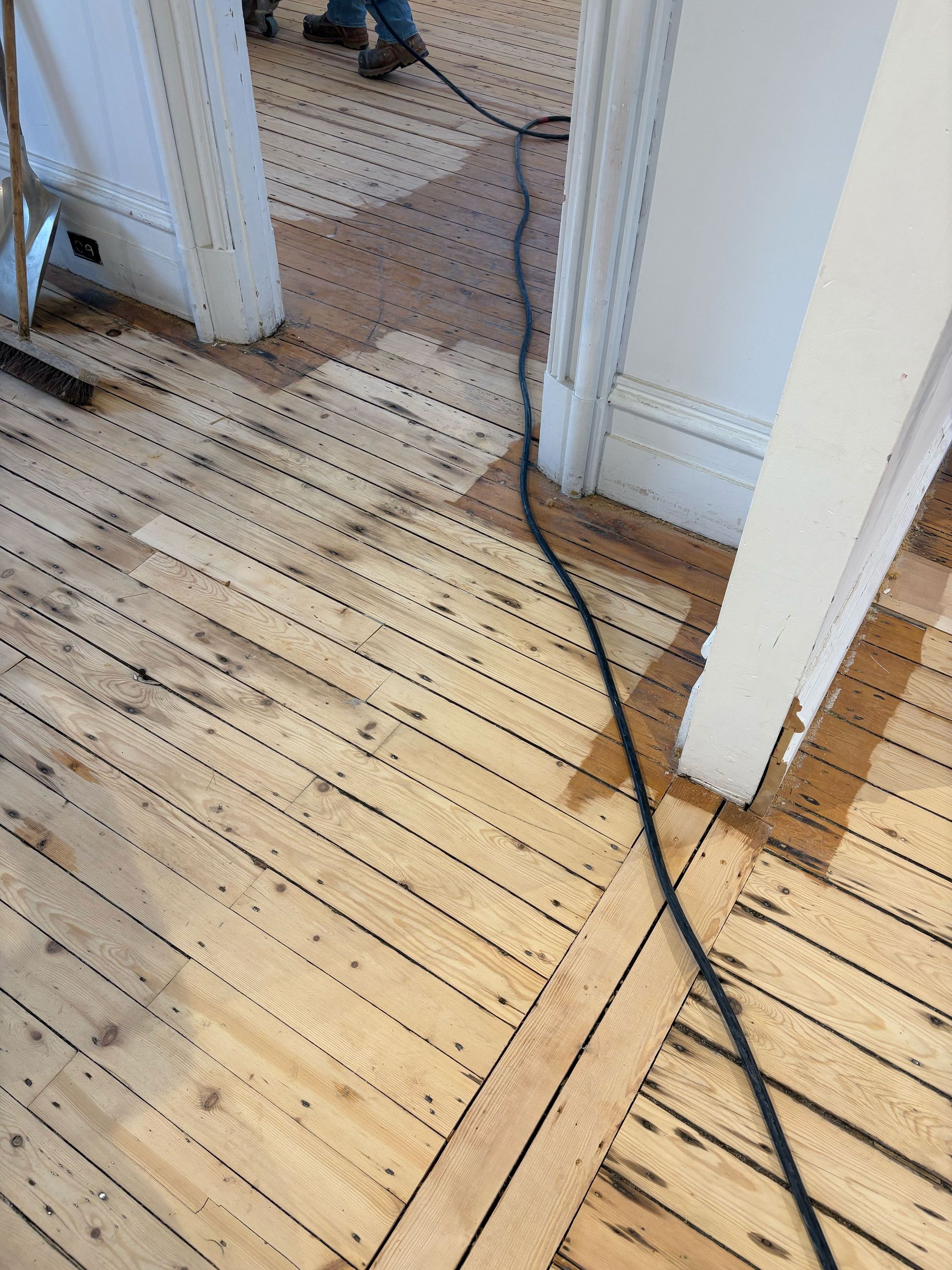 Un plancher en bois avec un aspirateur attaché dessus.