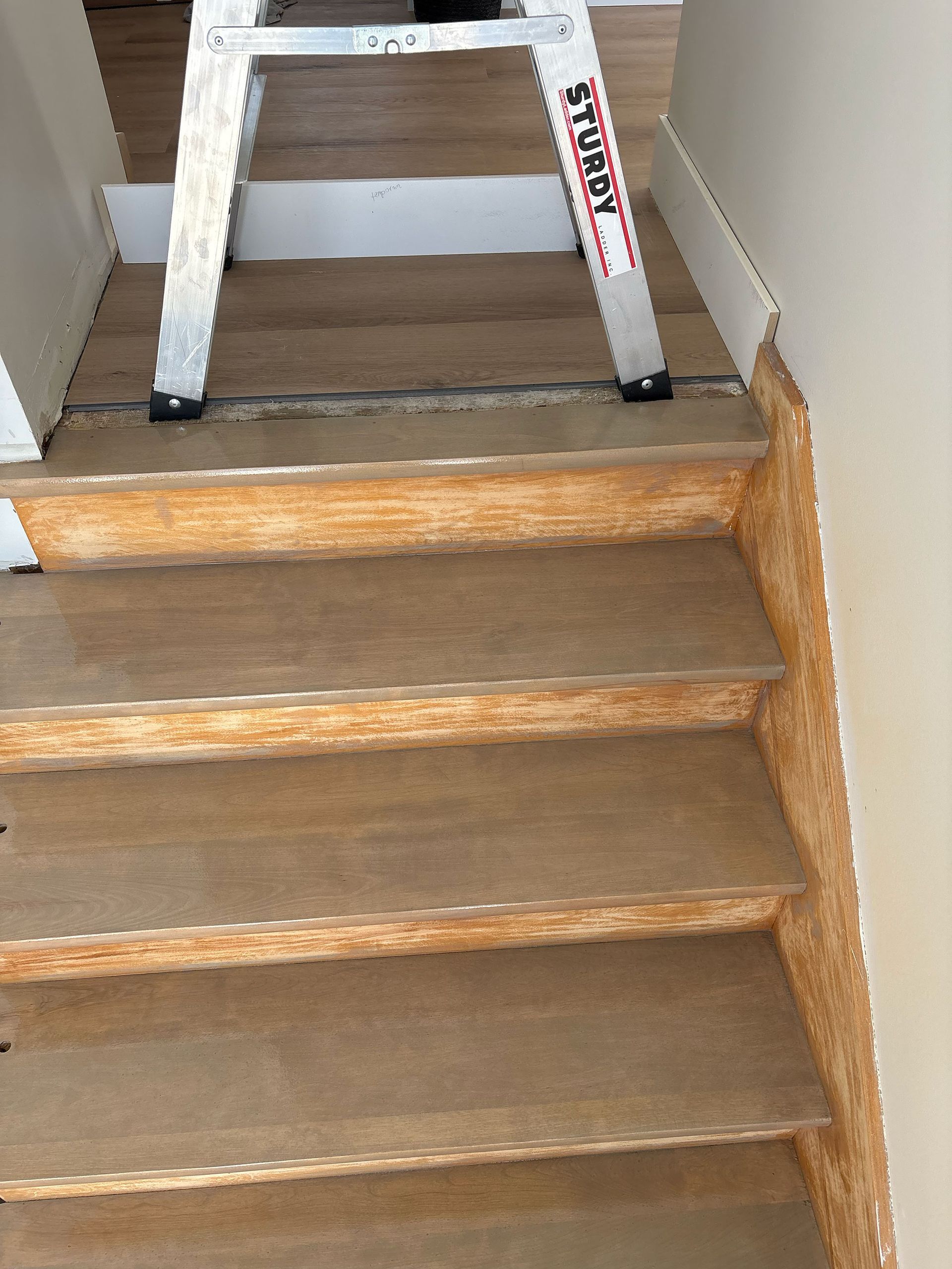 Une échelle est posée au sommet d'un escalier.