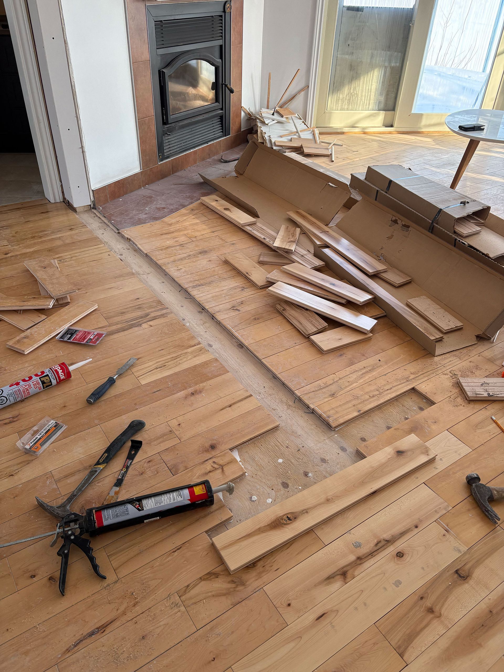 Un parquet est en cours d'installation dans un salon.