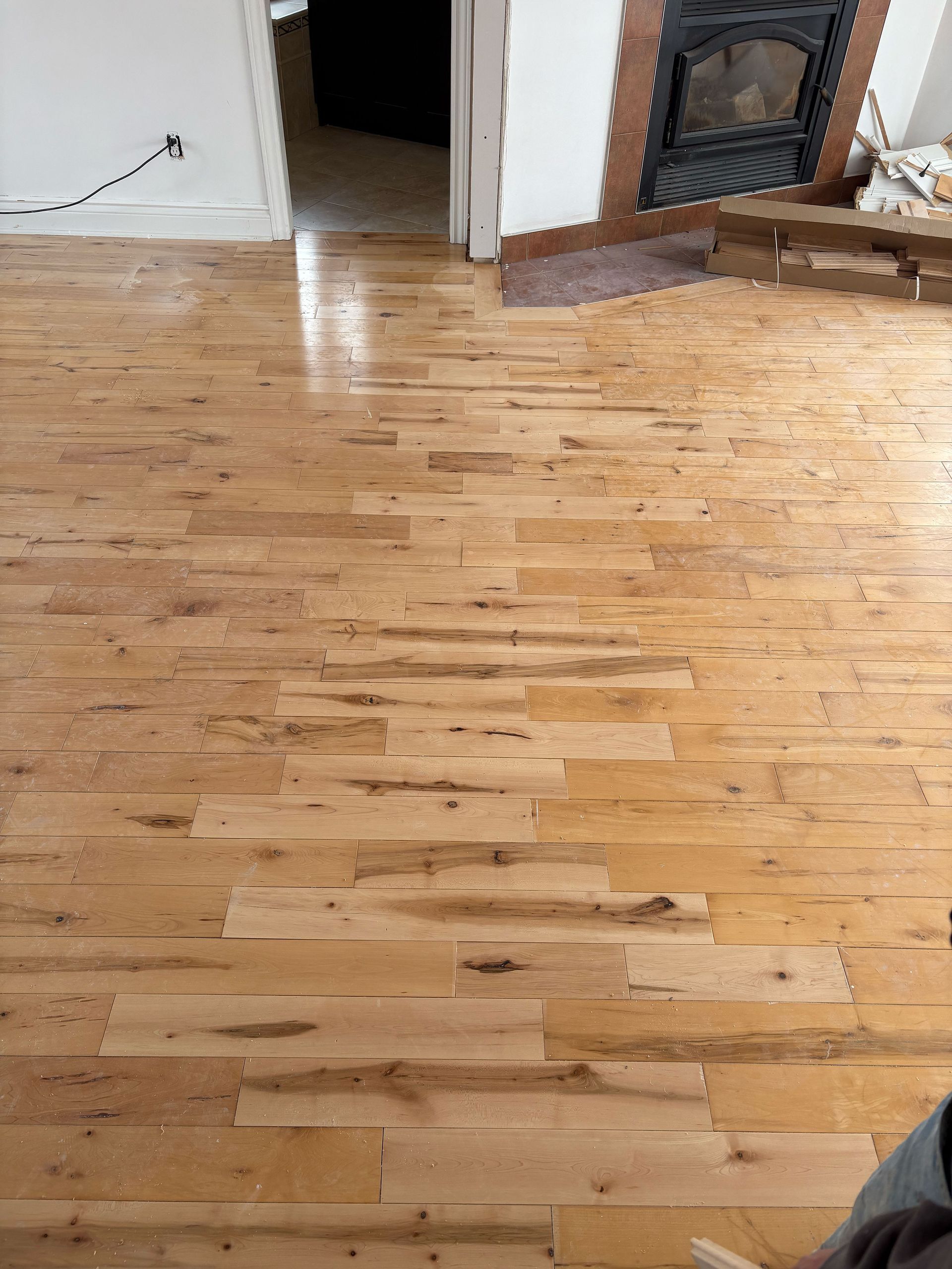 Un plancher en bois avec une cheminée en arrière-plan