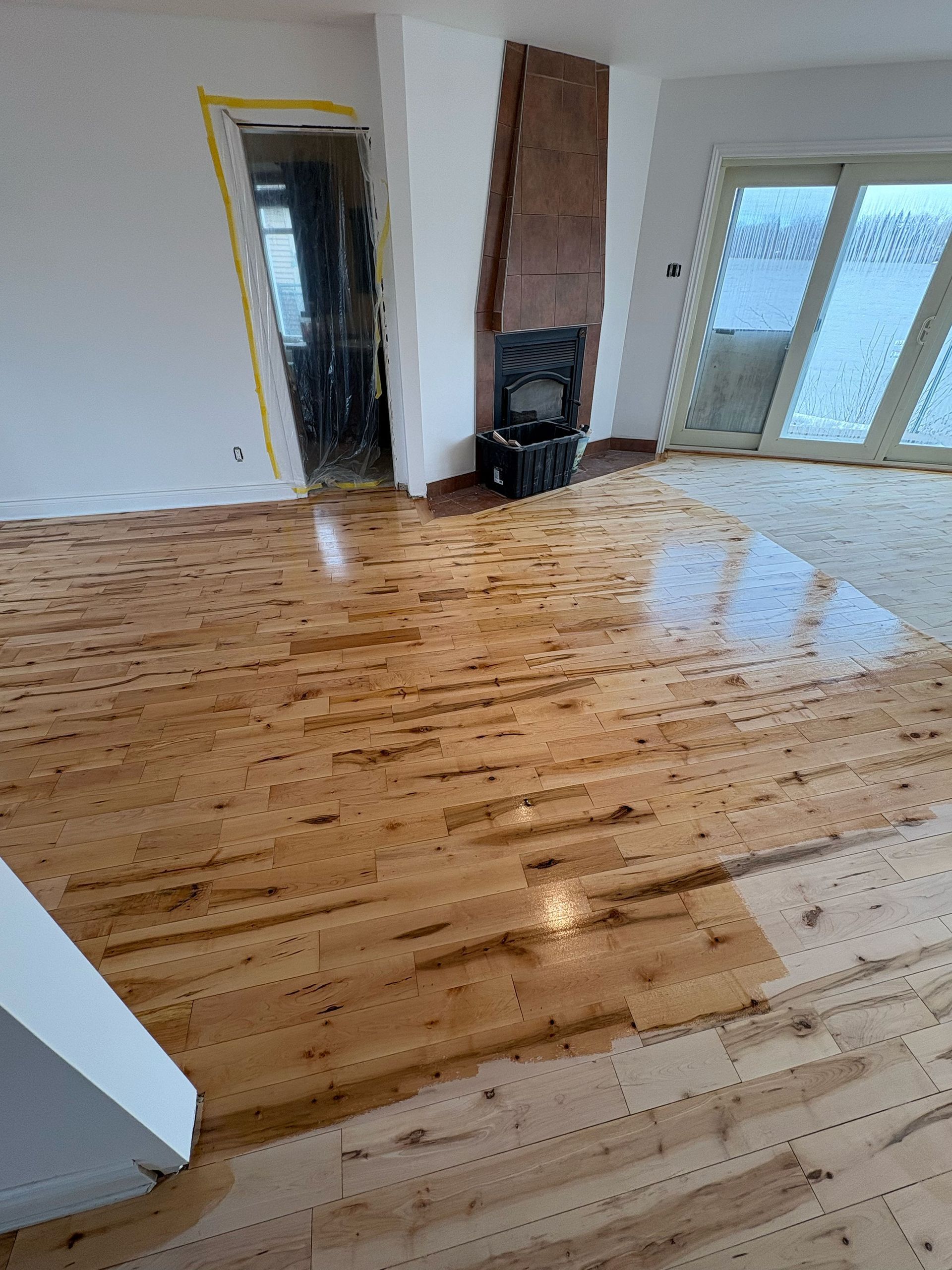 Un séjour avec un parquet et une cheminée.