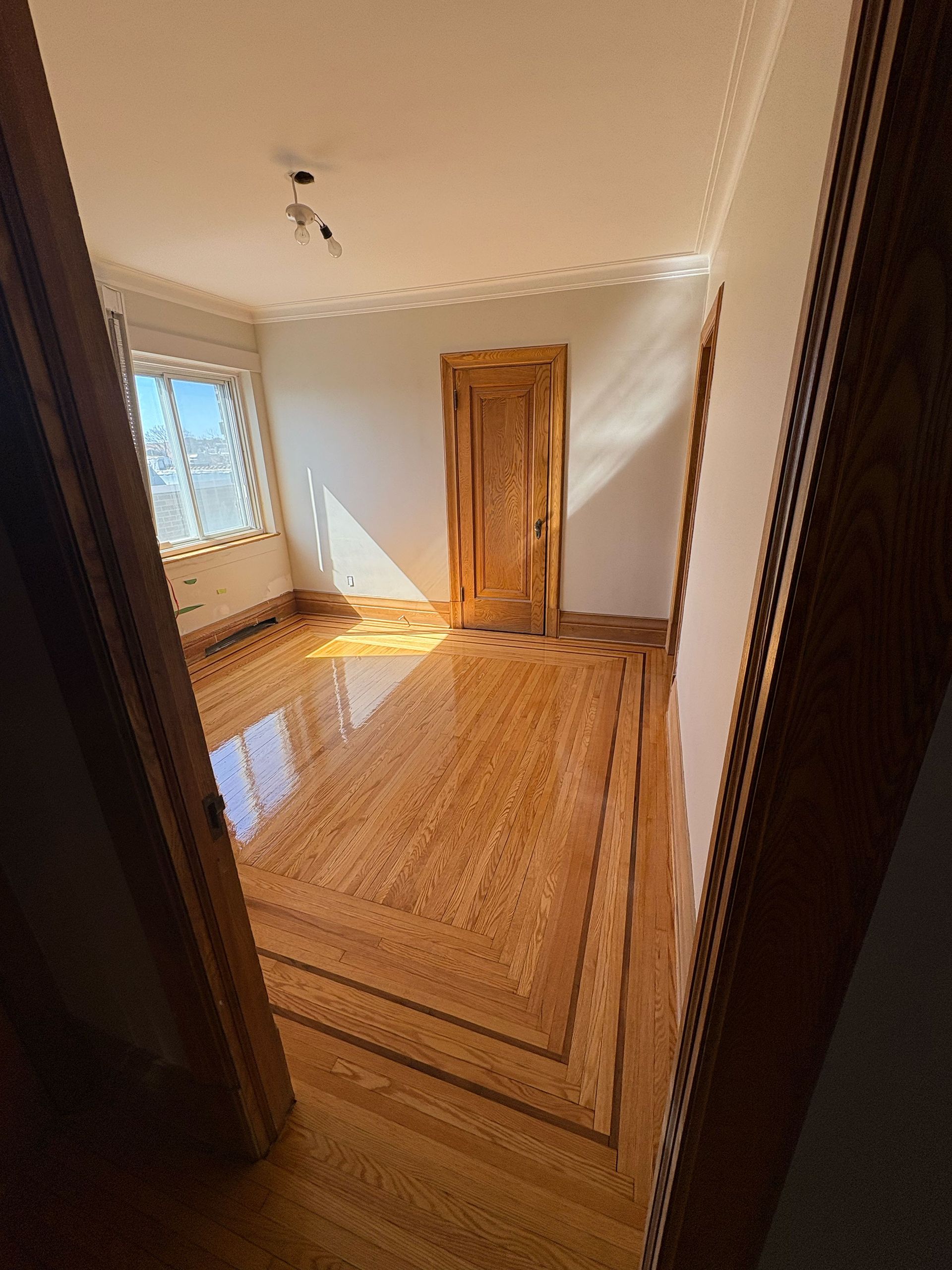 Une pièce avec un plancher en bois et une porte en bois.