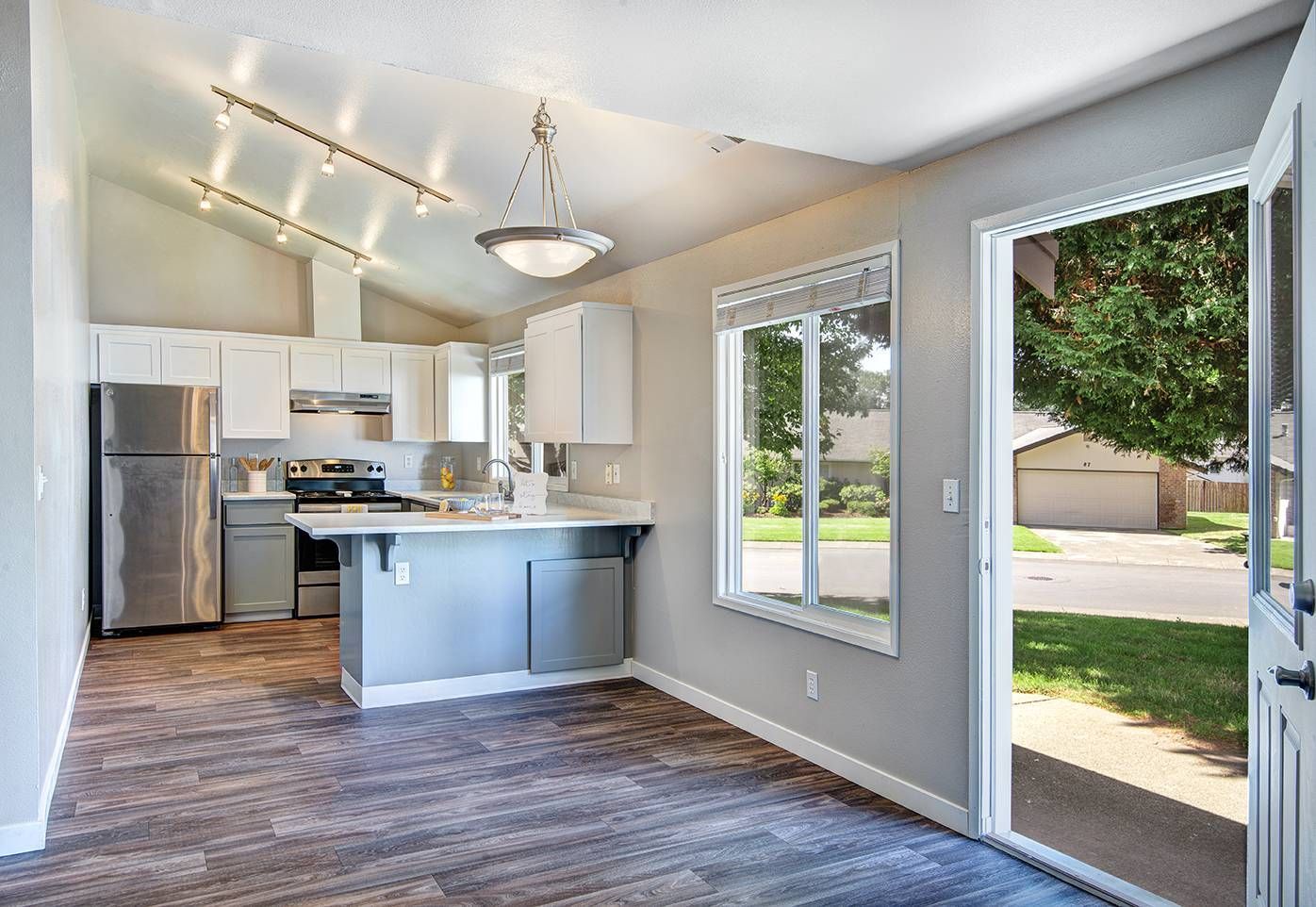Interior view of a modern kitchen in an apartment with white cabinets and stainless steel appliances.