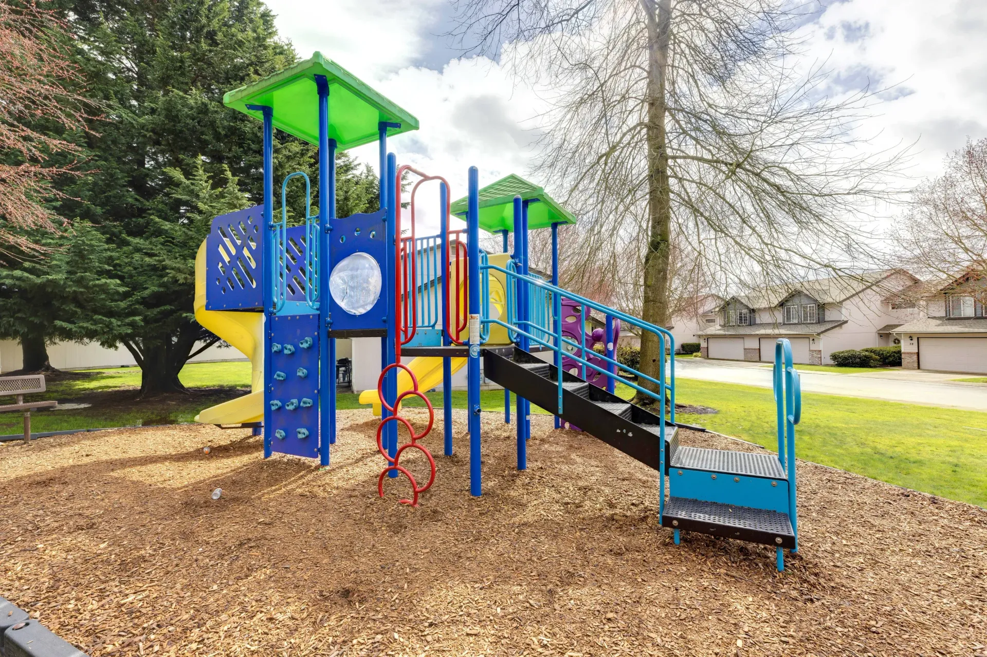 Colorful outdoor playground with slides and climbing structures at an apartment community.