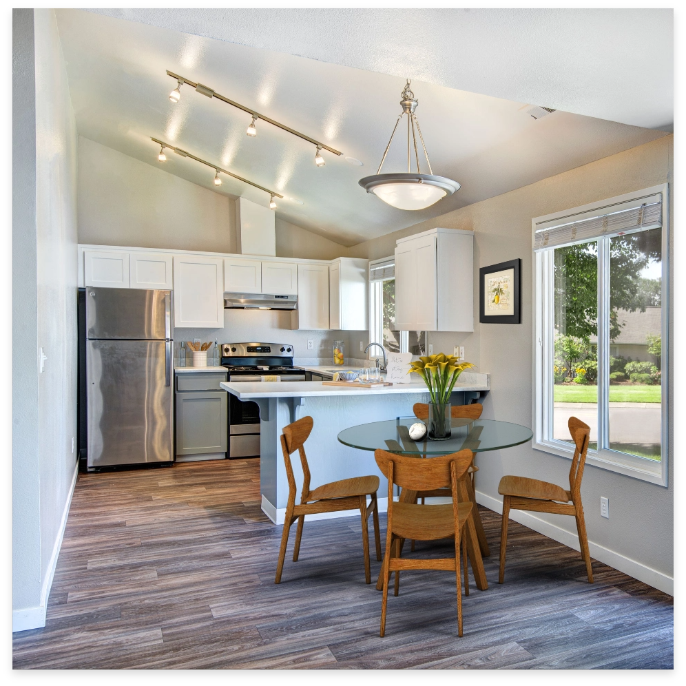Kitchen and dining area with gray and white cabinets, stainless steel appliances, and a glass table.