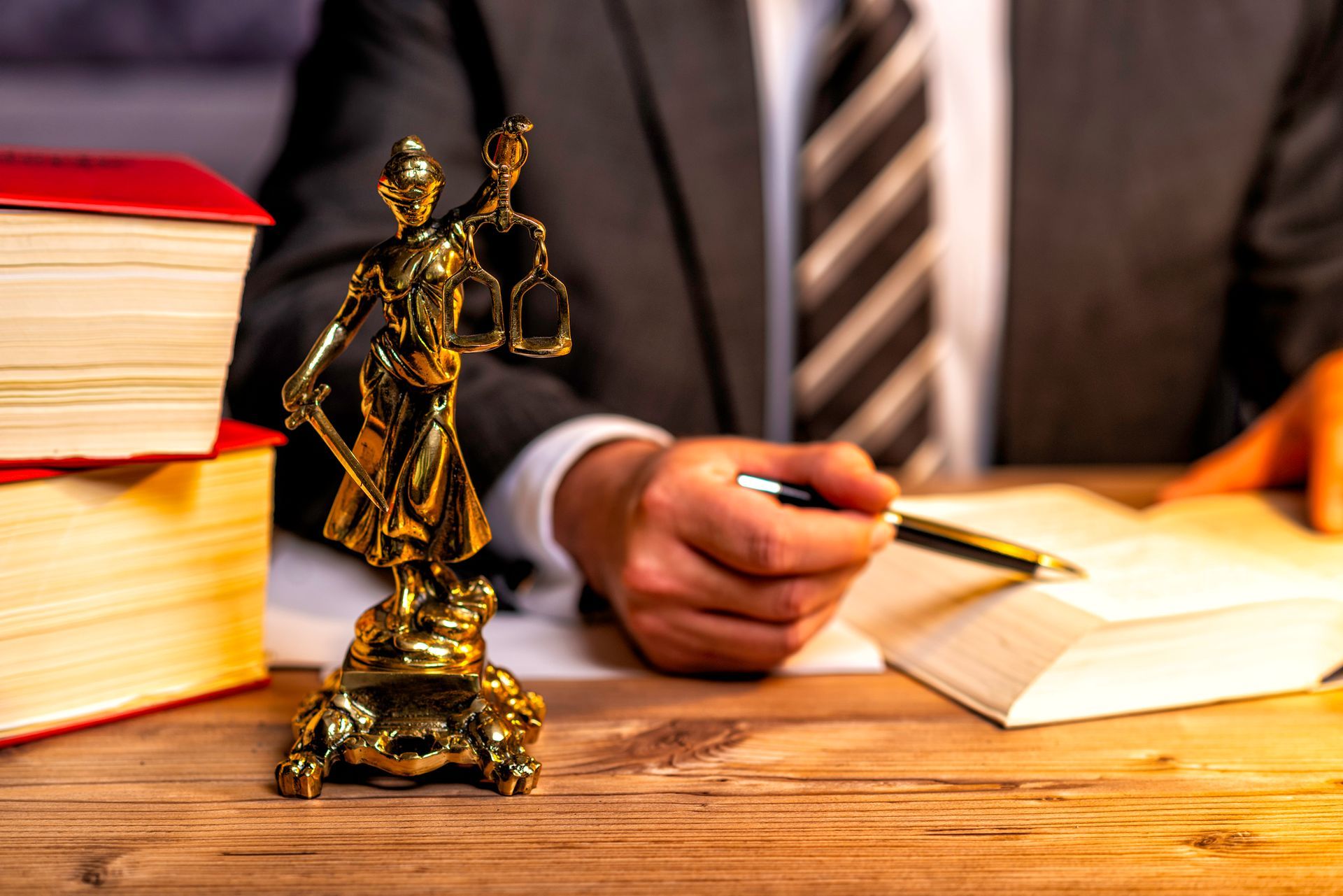 Office of a lawyer with a statue of Lady Justice, goddess Justitia, on the desk.