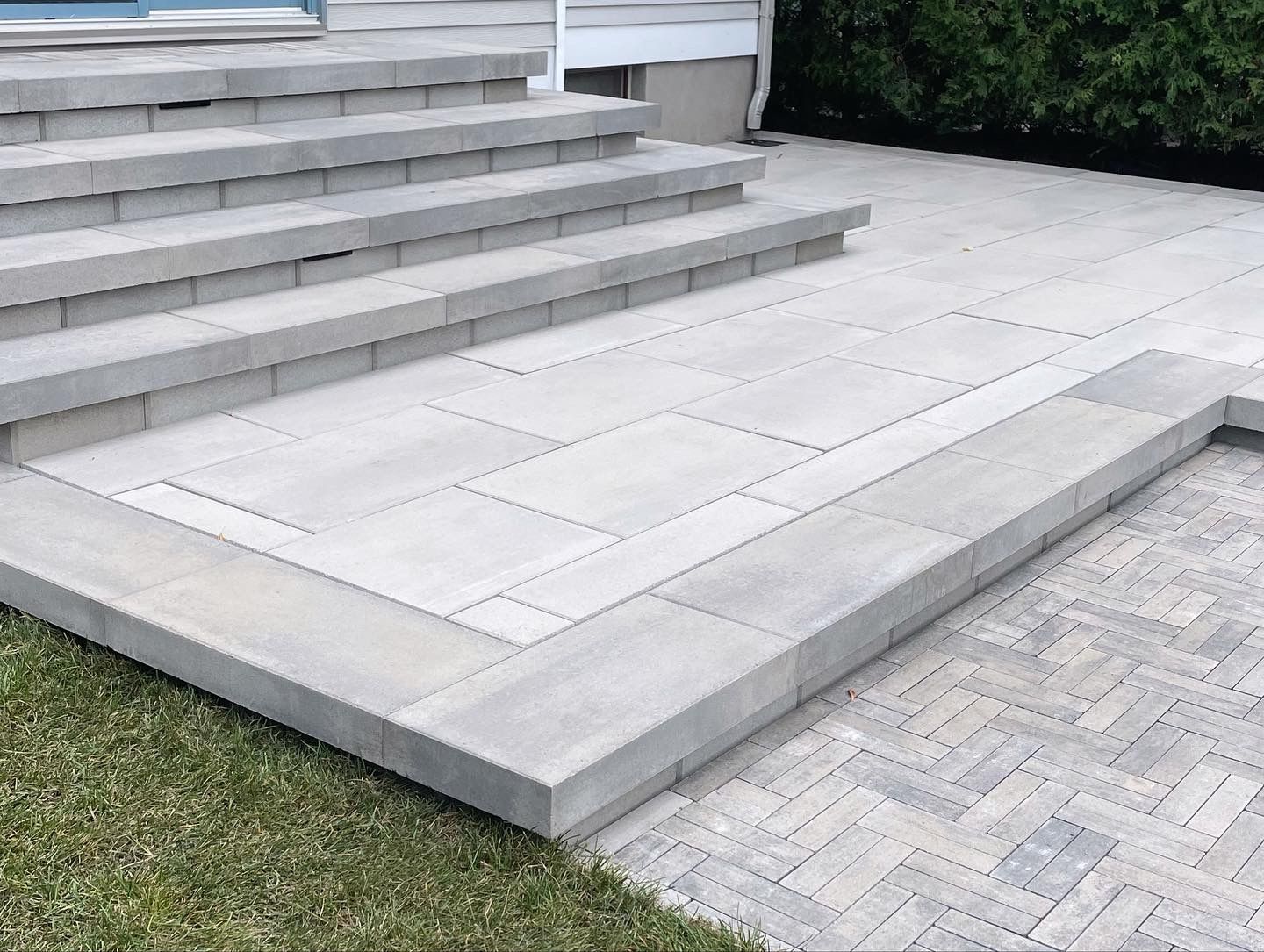 a set of stairs leading up to a patio with a brick walkway .