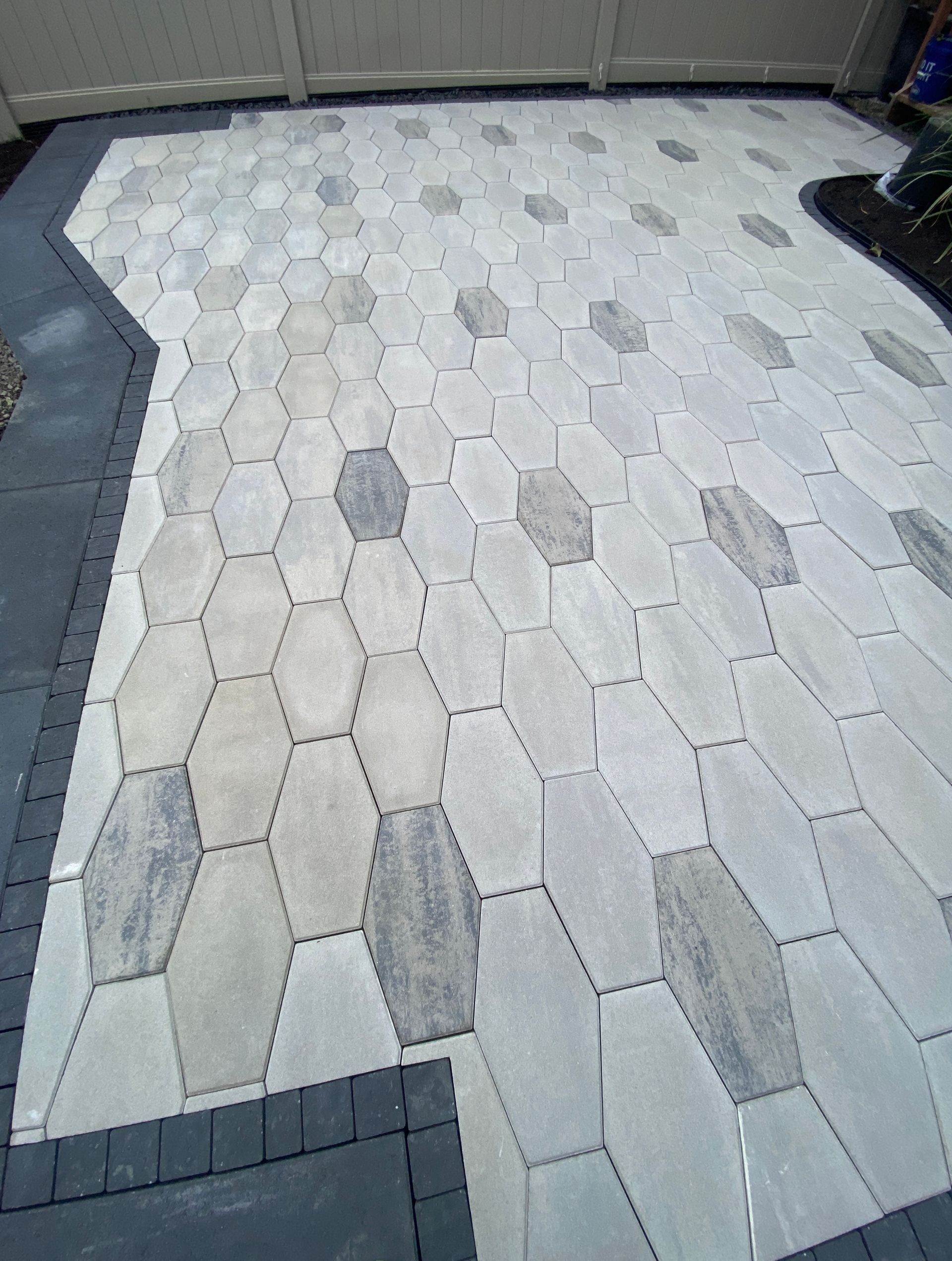 a patio with hexagonal tiles and a black border