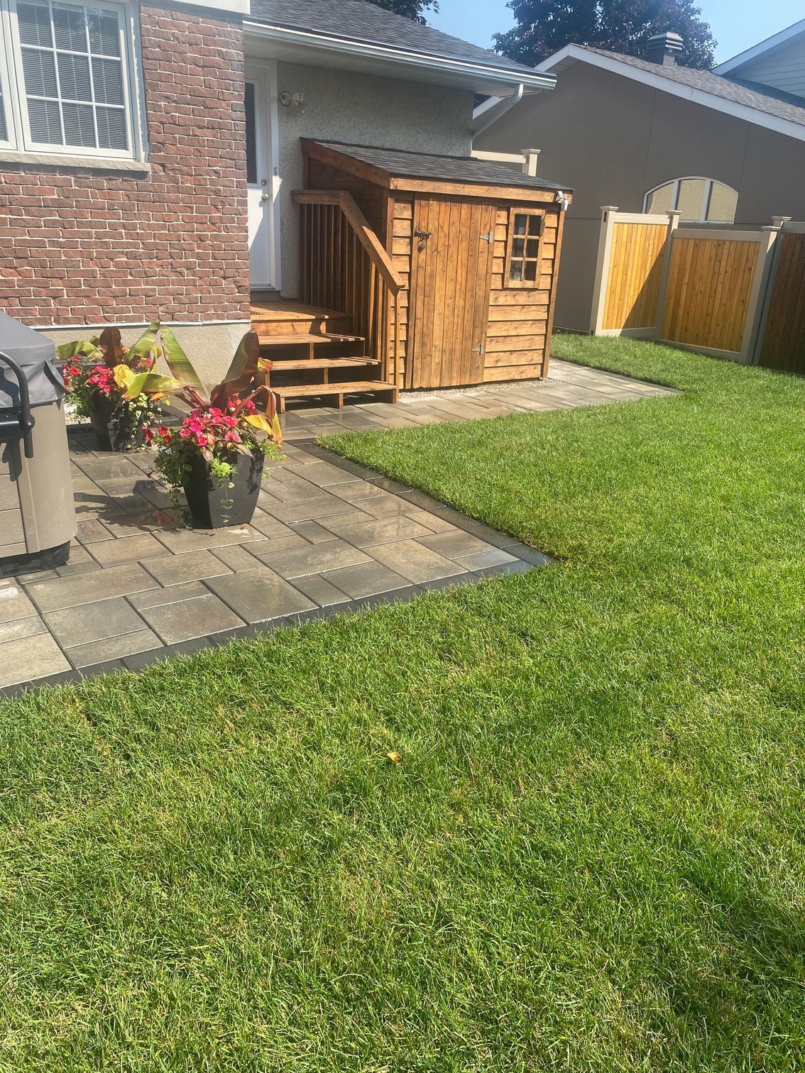 there is a wooden shed in the backyard of a house .