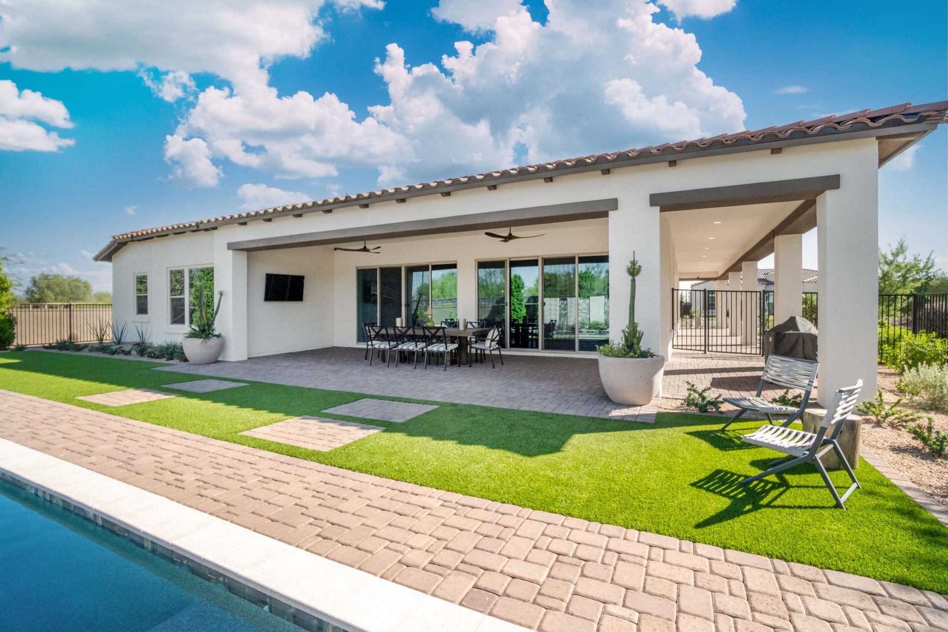 A large white house with a swimming pool in front of it.