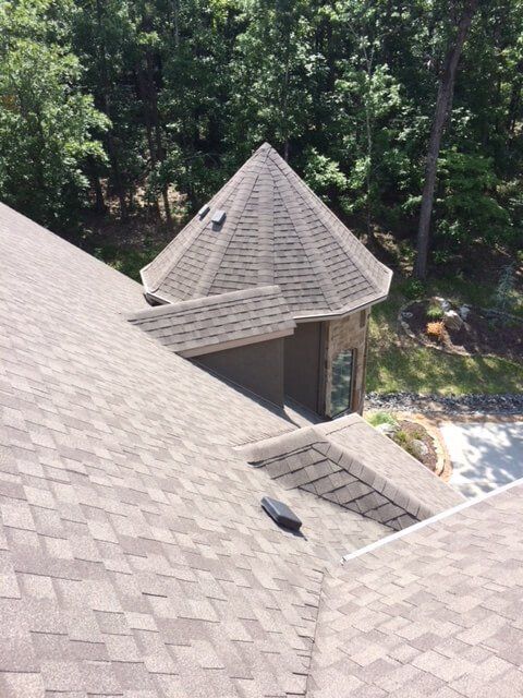 An aerial view of a roof with trees in the background