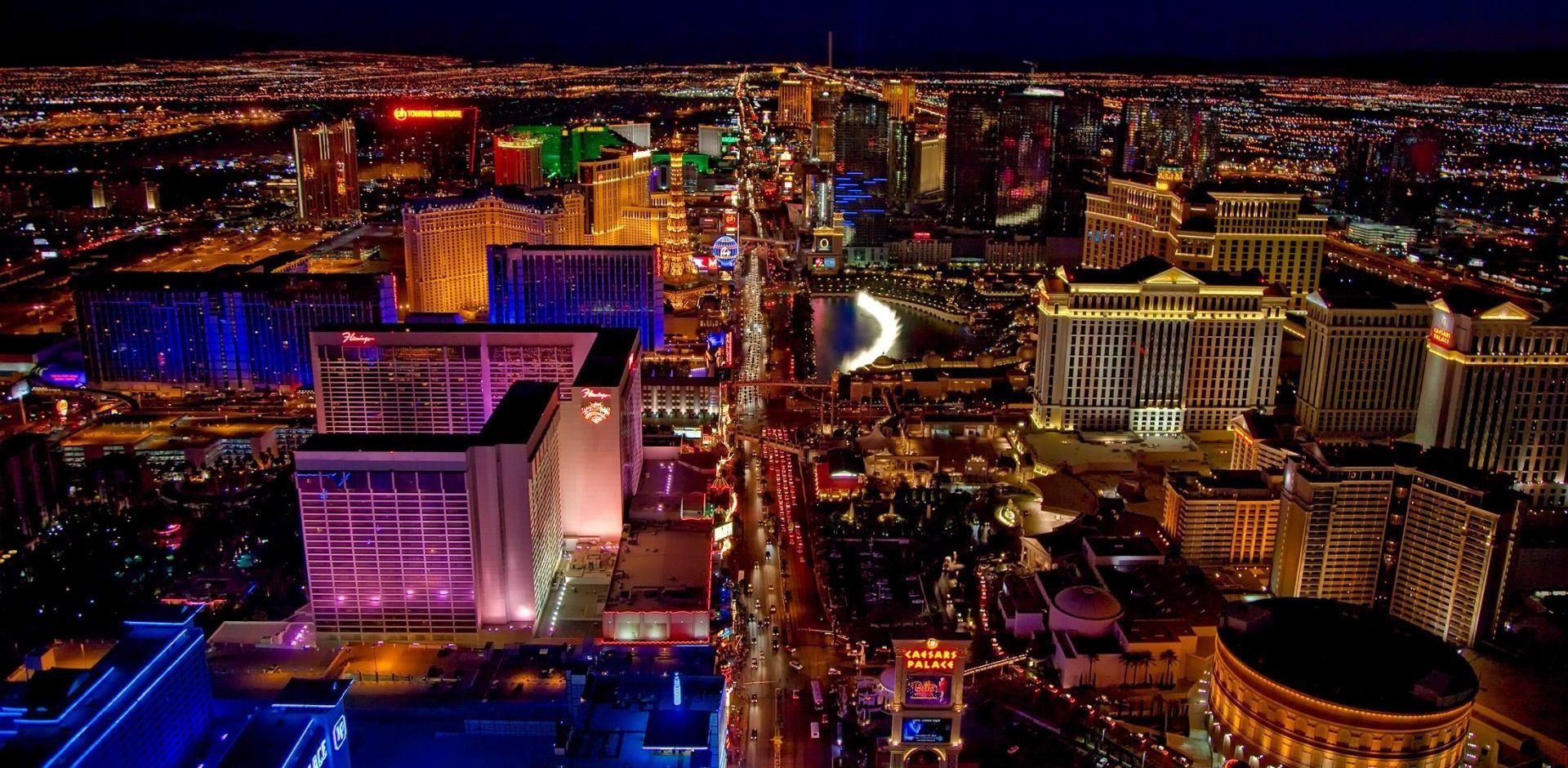 An aerial view of a city at night with lots of buildings lit up.