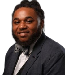 A woman wearing a black jacket and a green shirt smiles for the camera