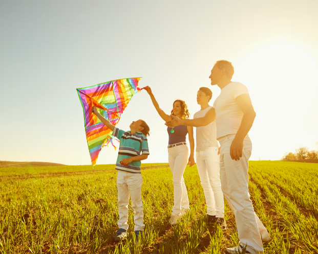 A family is flying a kite in a field