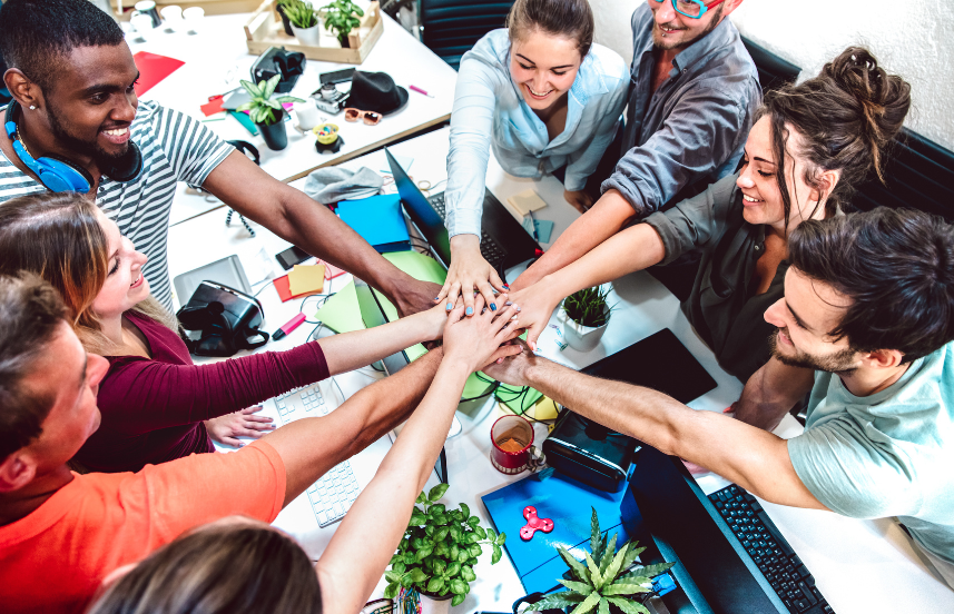 A group of people putting their hands together in a circle