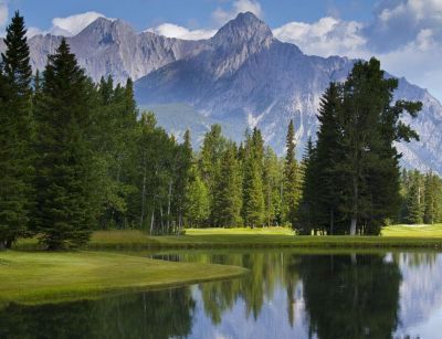 A lake surrounded by trees with mountains in the background