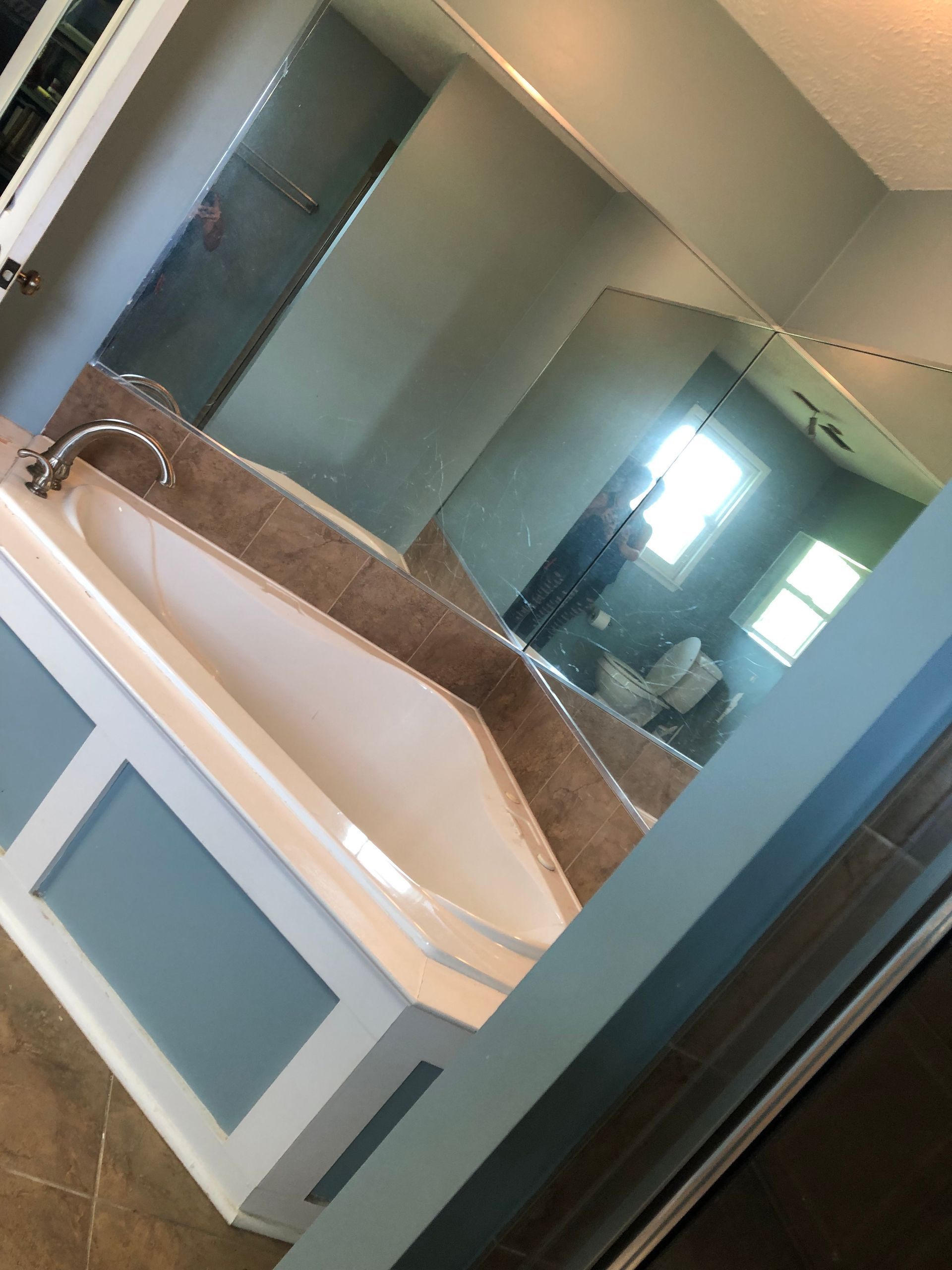 A bathroom with a bathtub and a large mirror