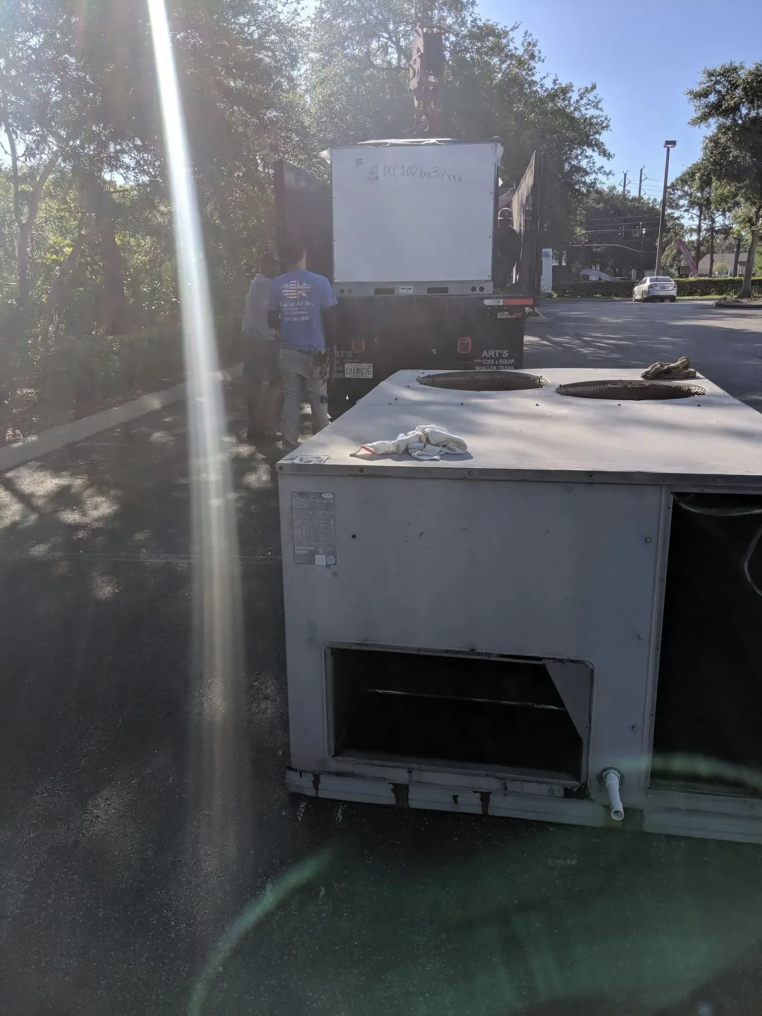 A man is standing next to a large white box on the side of a road.