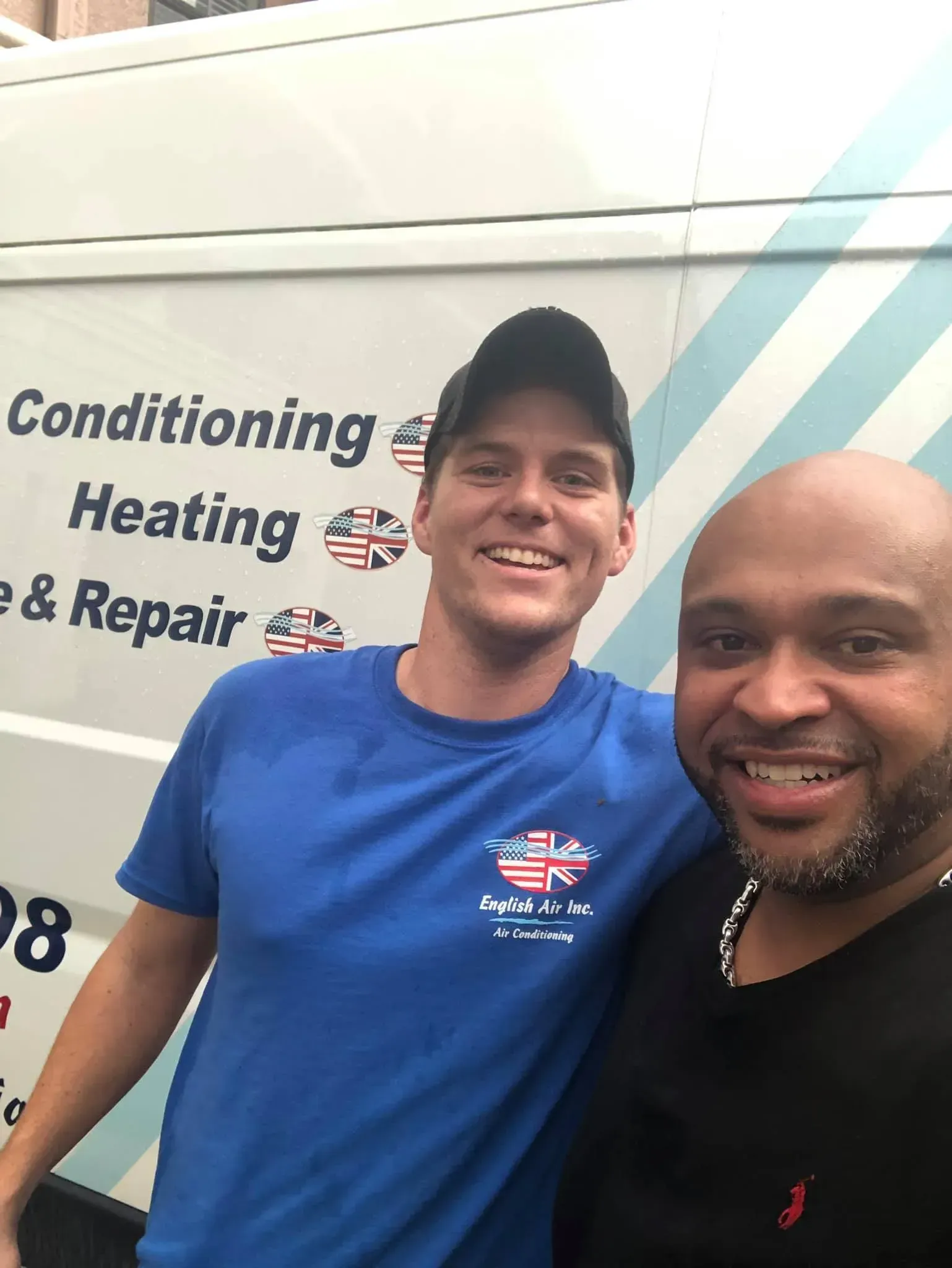 Two men are posing for a picture in front of a van that says conditioning heating and repair.