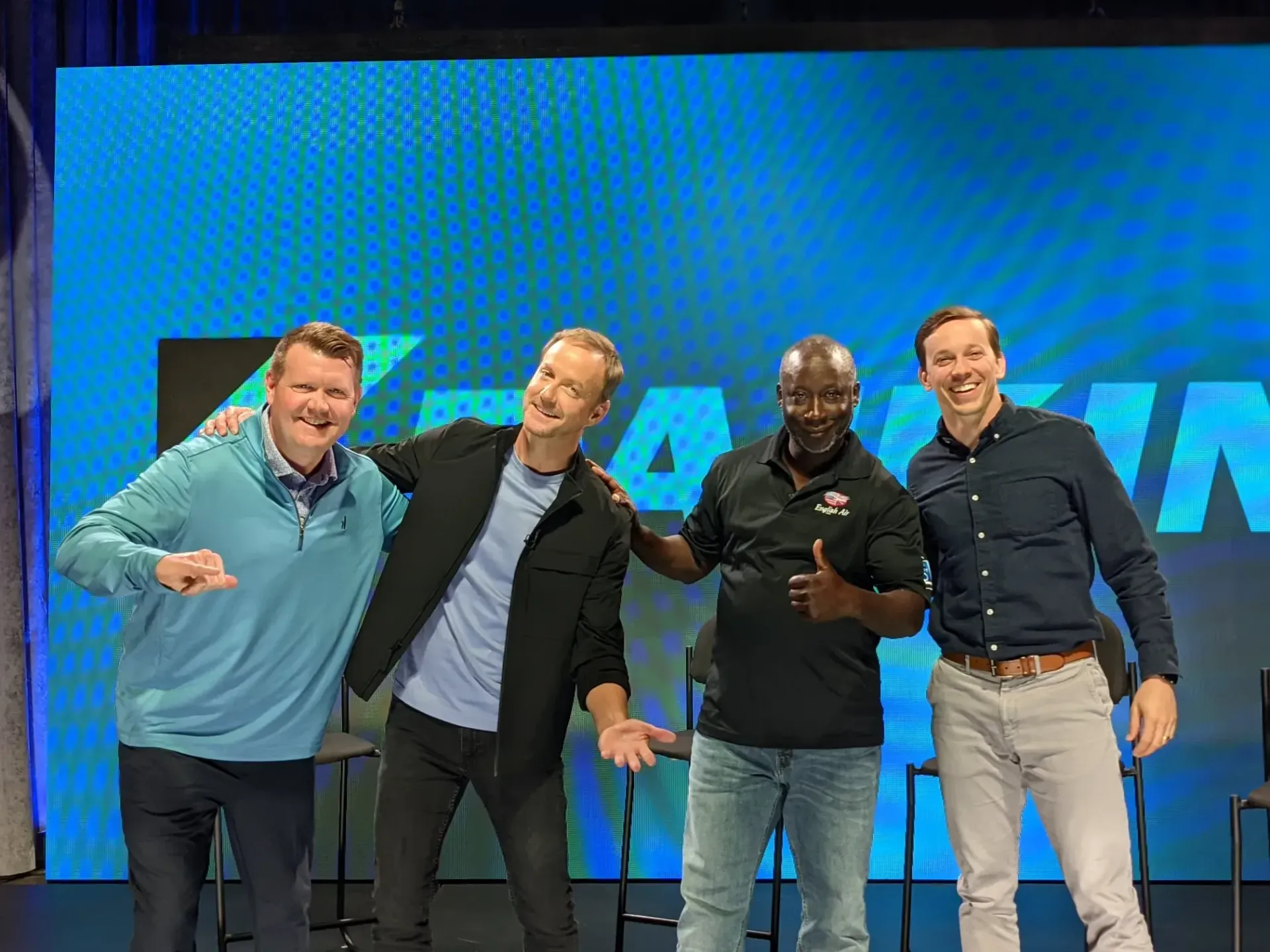 A group of men are posing for a picture on a stage.