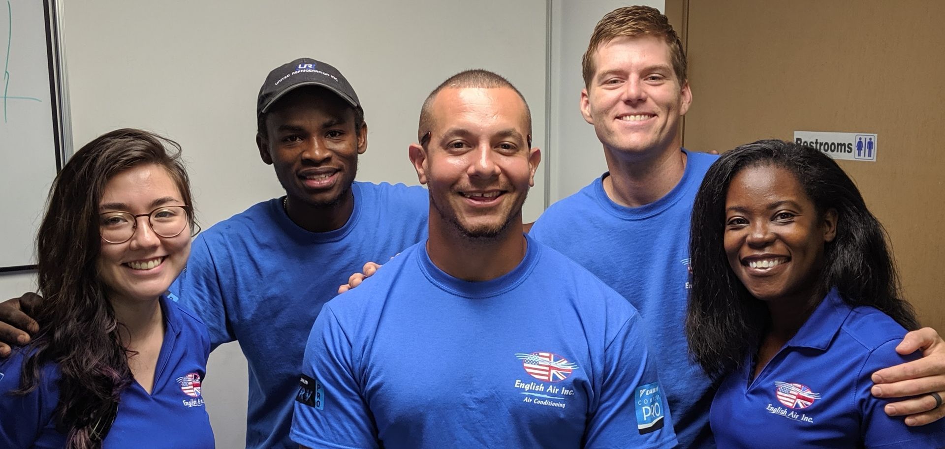 A group of people wearing blue shirts are posing for a picture.