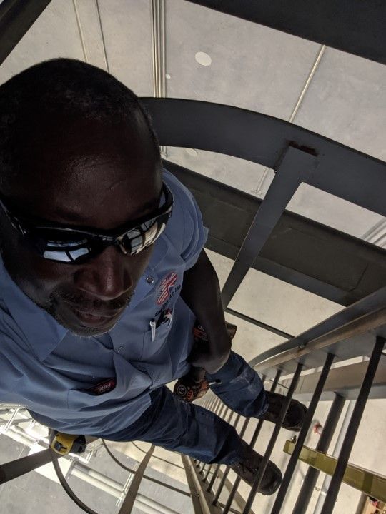 A man wearing sunglasses is standing on a set of stairs
