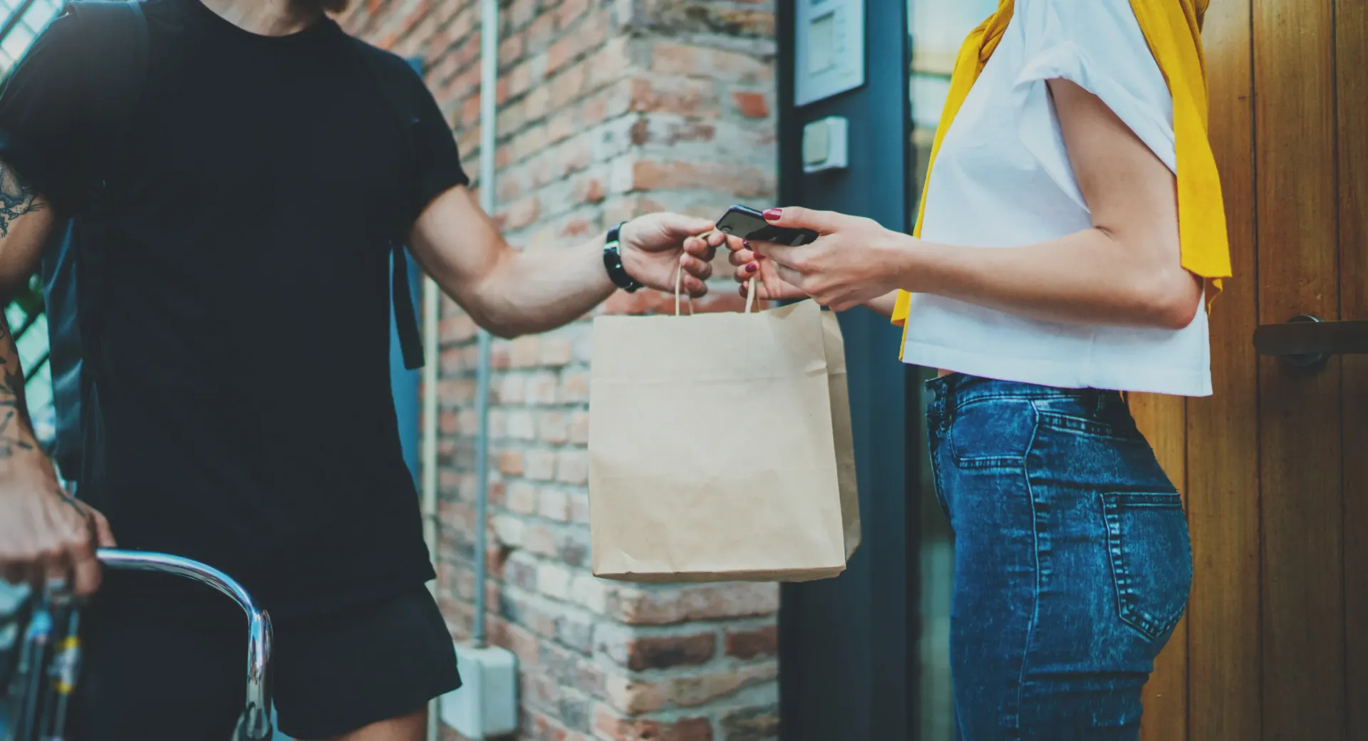 A man is giving a woman a bag of food.