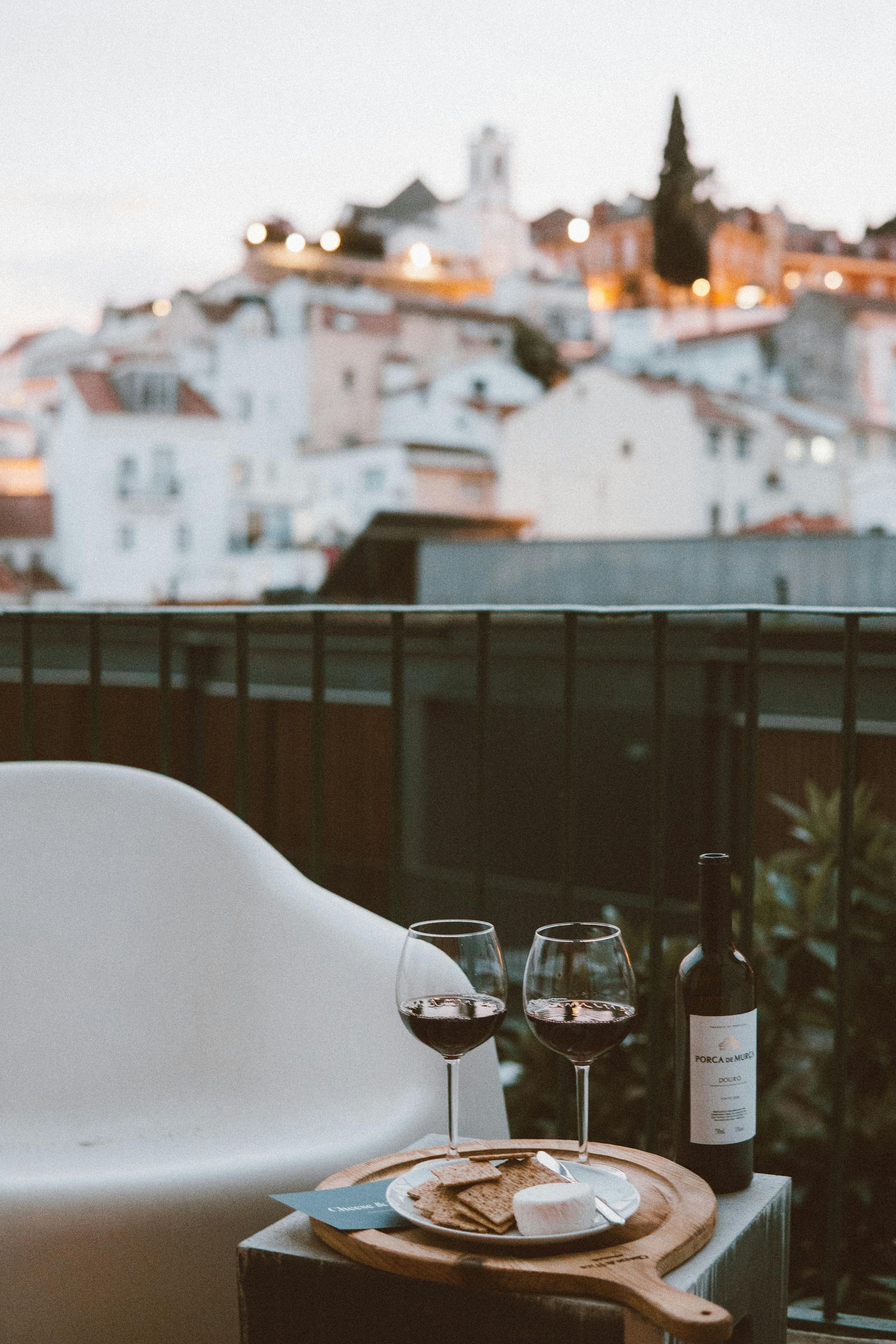 A bottle of wine sits on a table next to two glasses of wine