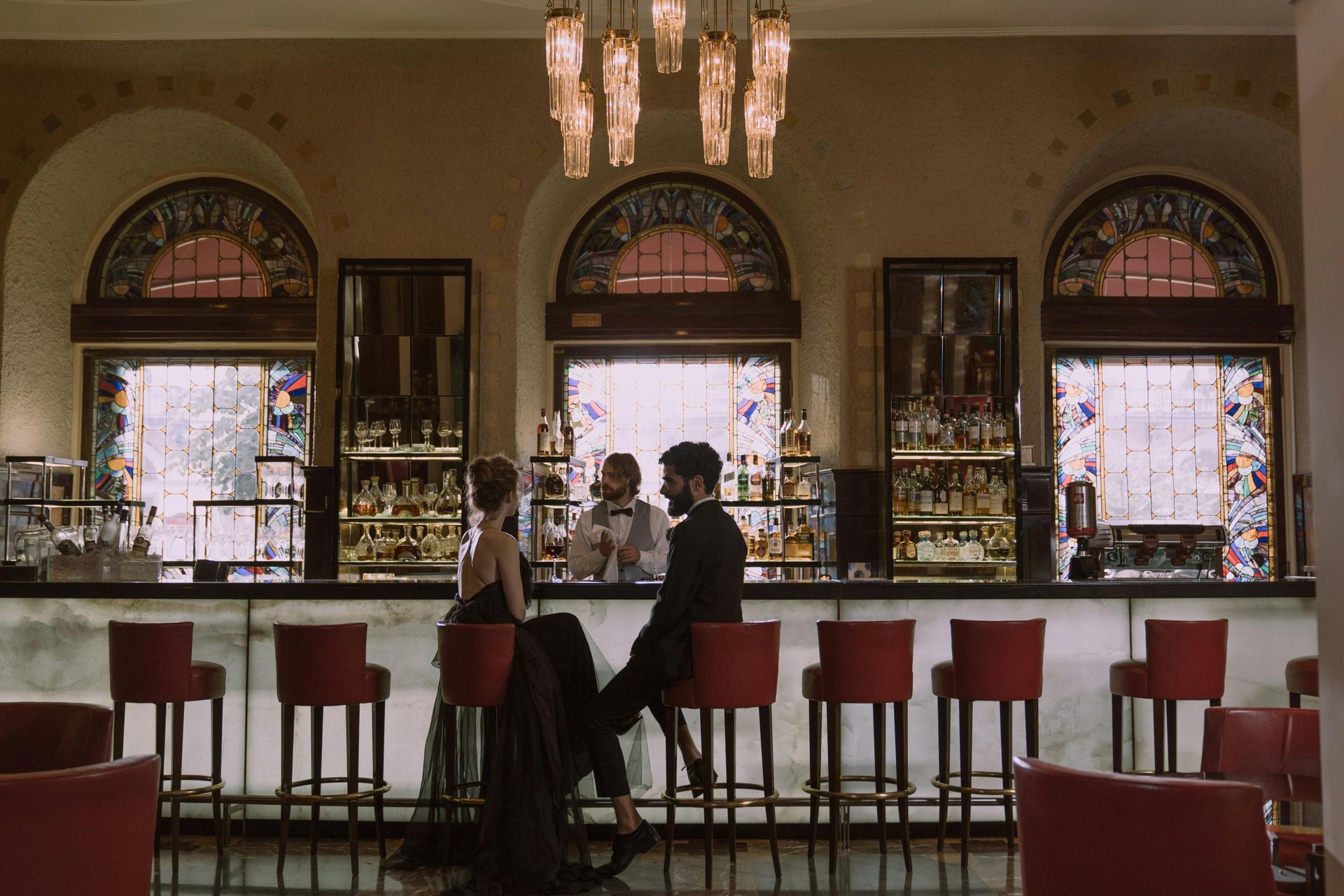 A man and woman are sitting at a bar in a restaurant.