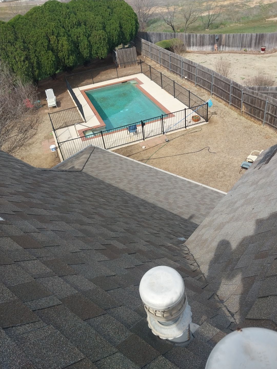 An aerial view of a swimming pool from the roof of a house