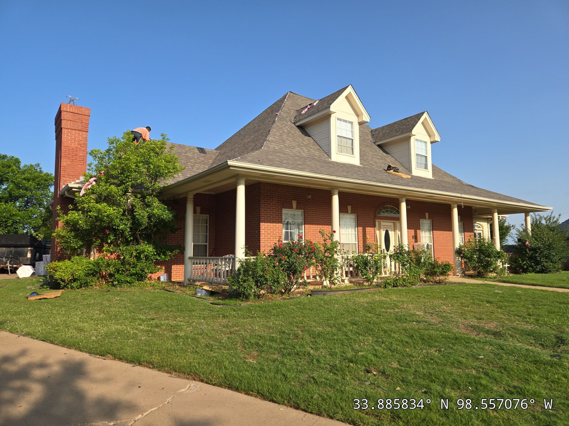 A large brick house with a porch and a chimney