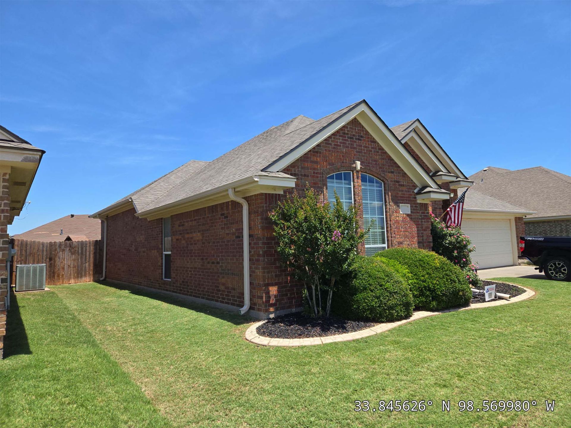 A brick house with a large lawn in front of it