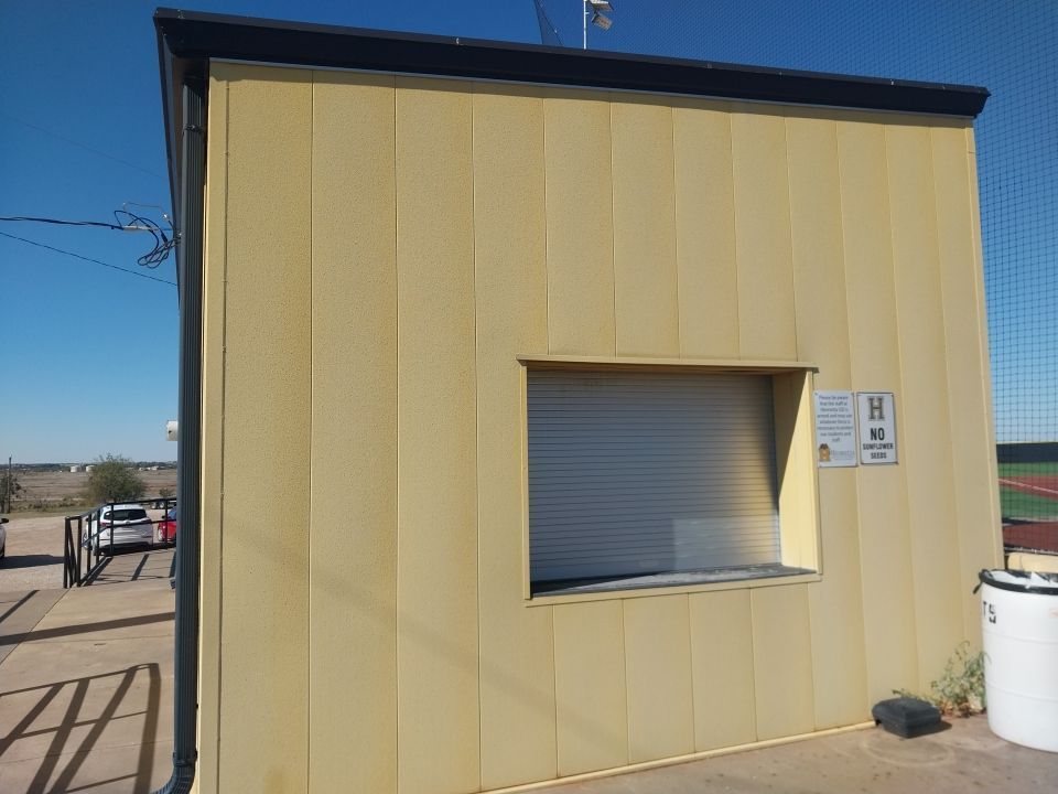 A yellow building with a window and a sign on it