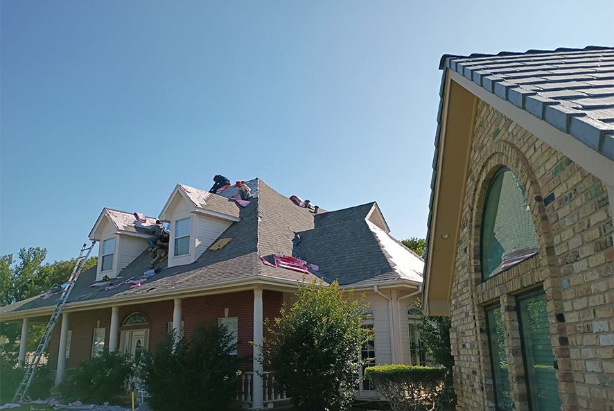 A large brick house with a roof that is being repaired