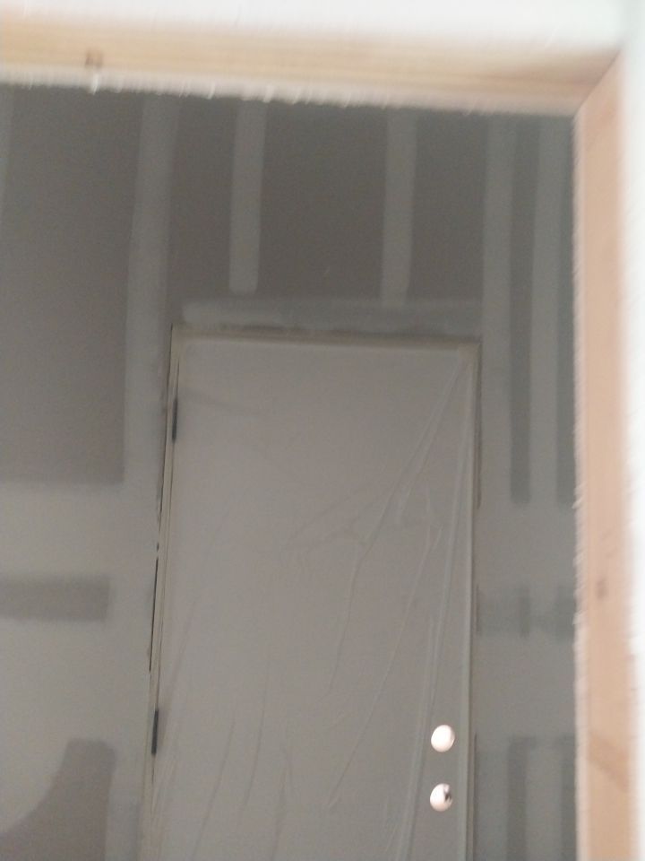 A door is being built into a wall in a room.