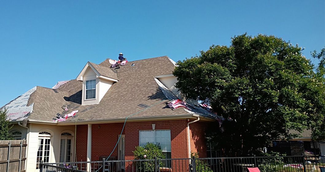 A man is working on the roof of a house.
