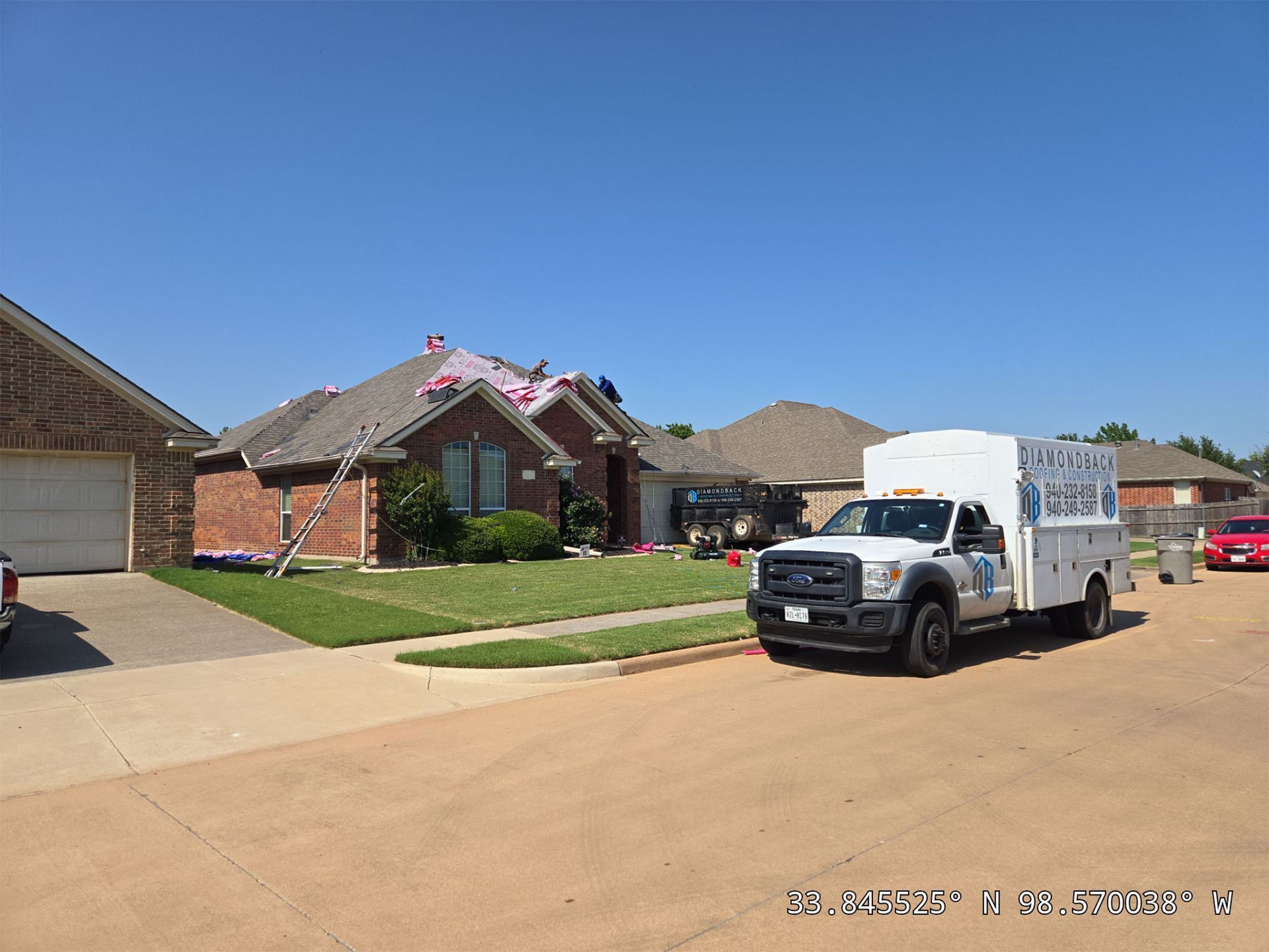 A white truck is parked in front of a house.